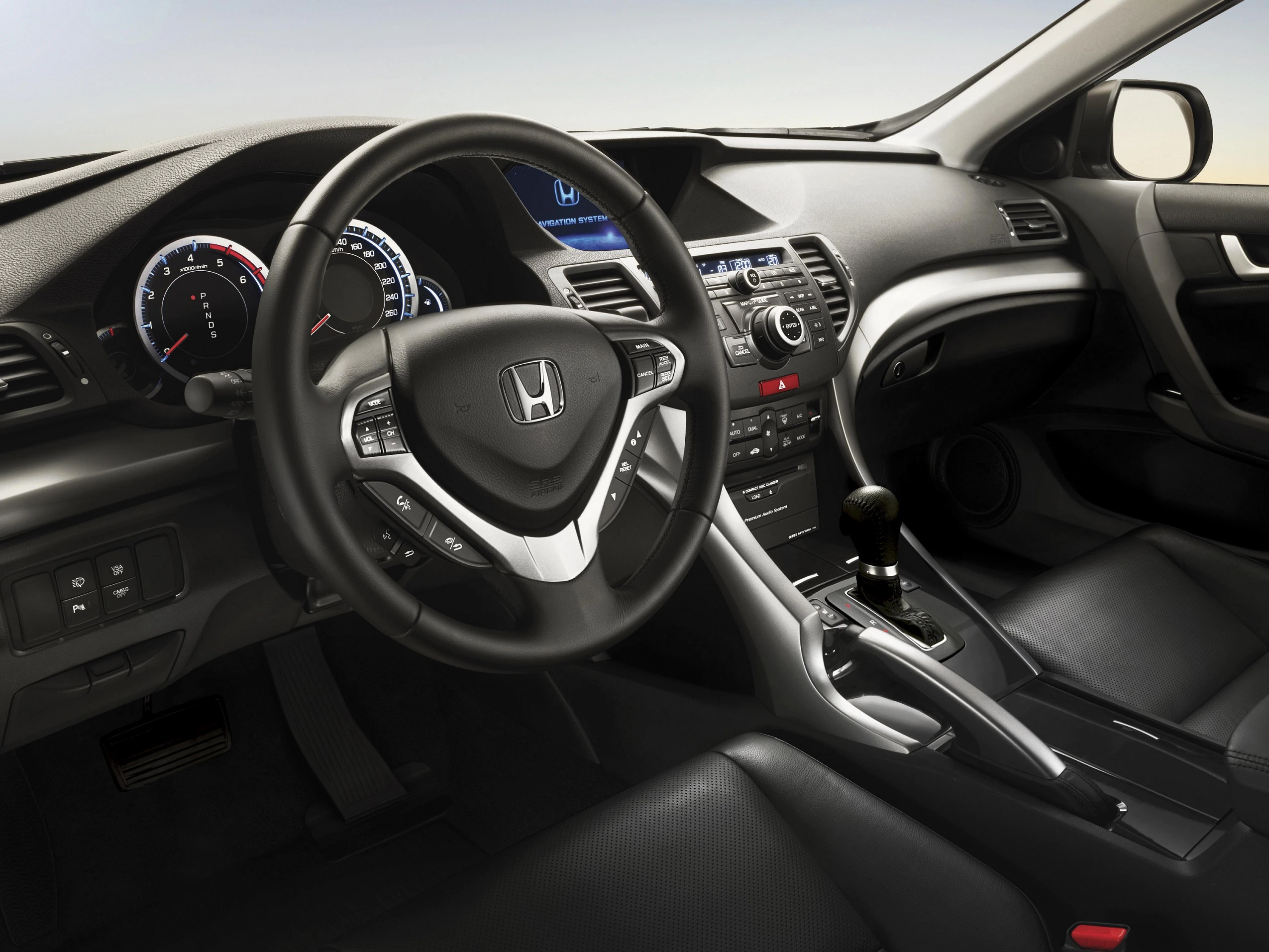 Lenkrad und Armaturenbrett eines modernen Autos mit großem Display und Drehzahlmesser. Schwarze Ledersitze und elegante Innenausstattung.