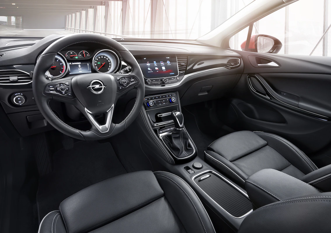Innenraum eines modernen Autos mit Lederlenkrad, Touchscreen-Display und Mittelkonsole. Elegantes Design mit schwarzer Lederausstattung.