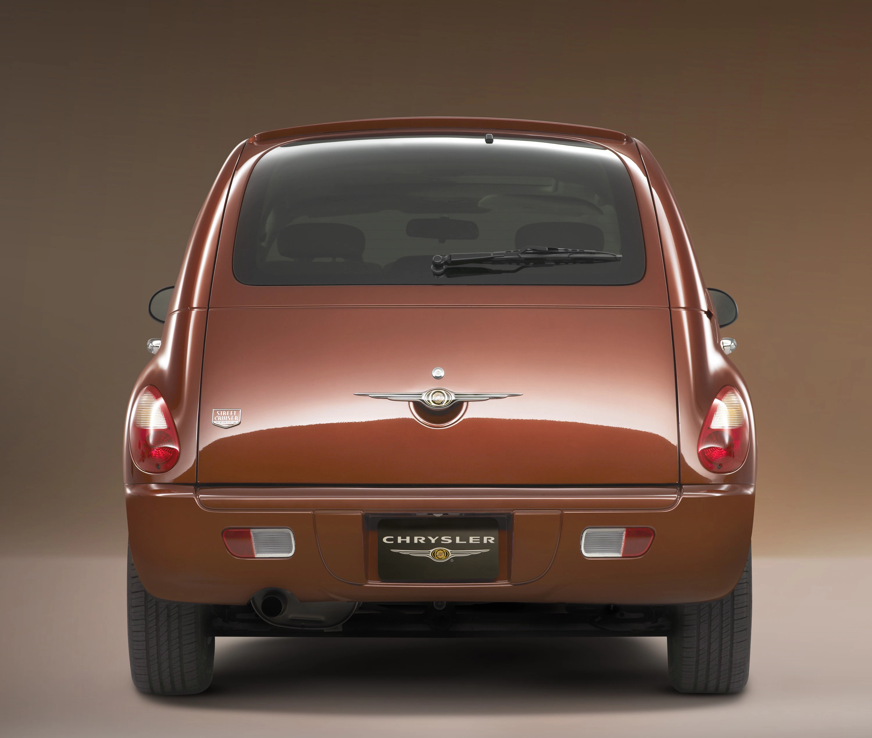 Rückansicht eines braunen Chrysler PT Cruiser im Studio mit beleuchtetem Hintergrund.