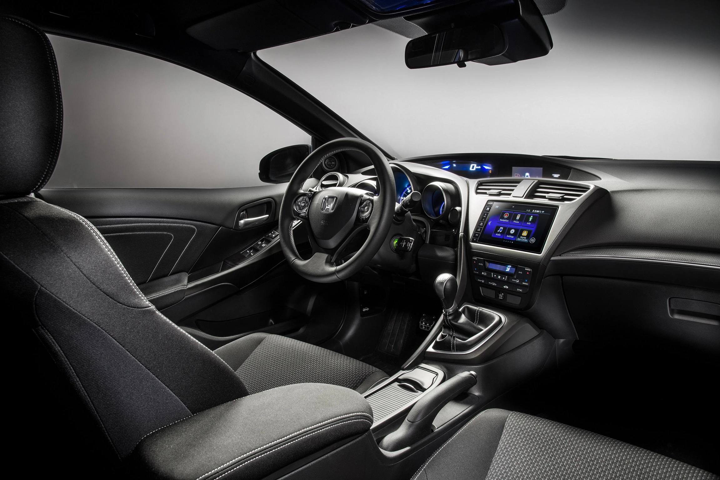 Innenraum eines modernen Autos mit schwarzer Polsterung, Multifunktionslenkrad und Touchscreen-Display auf der Mittelkonsole.