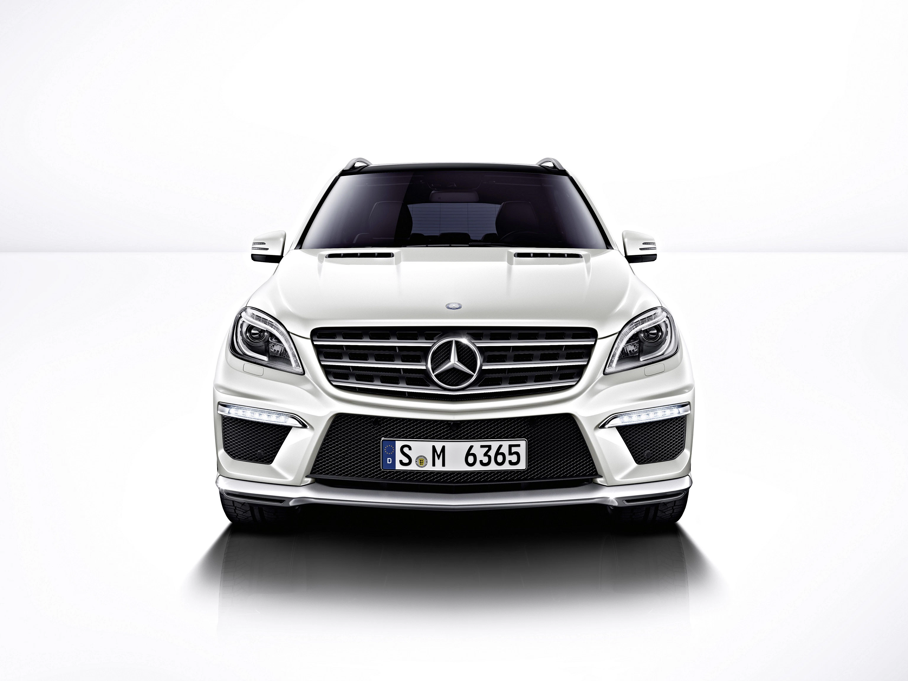 Weißer Mercedes-Benz SUV von vorne auf weißem Hintergrund, mit markantem Kühlergrill und Scheinwerfern.