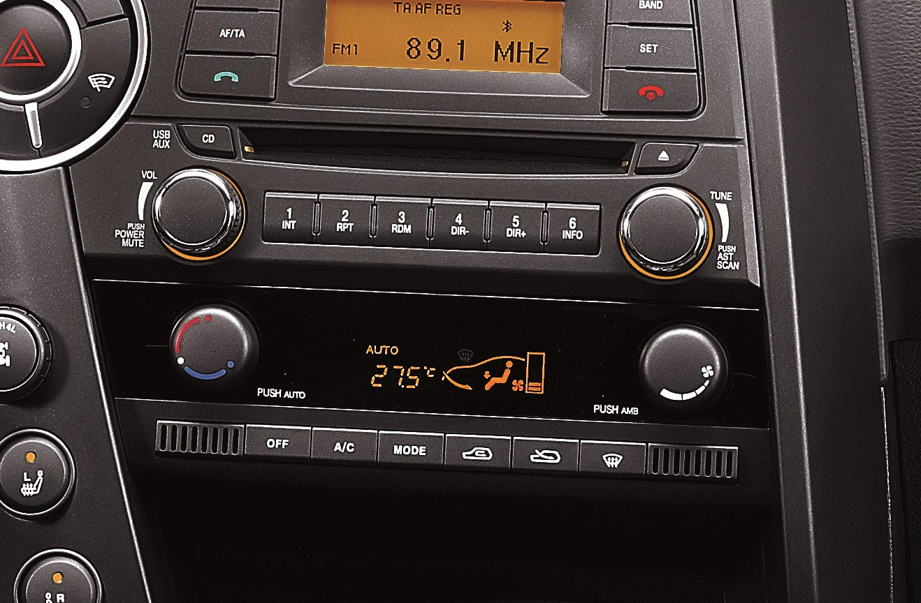 Autoradio und Klimasteuerung in einem Fahrzeug. Der Bildschirm zeigt FM-Radio und die Klimaanlage auf 21,5°C eingestellt.