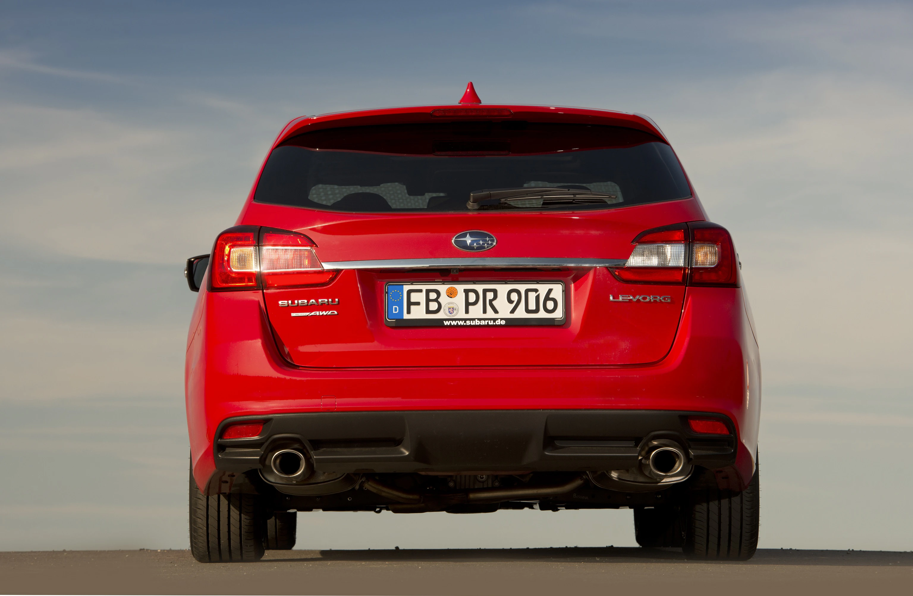Rotes Auto von hinten mit doppelauspuff. Kennzeichen "FB-PR 906". Blauer Himmel im Hintergrund.