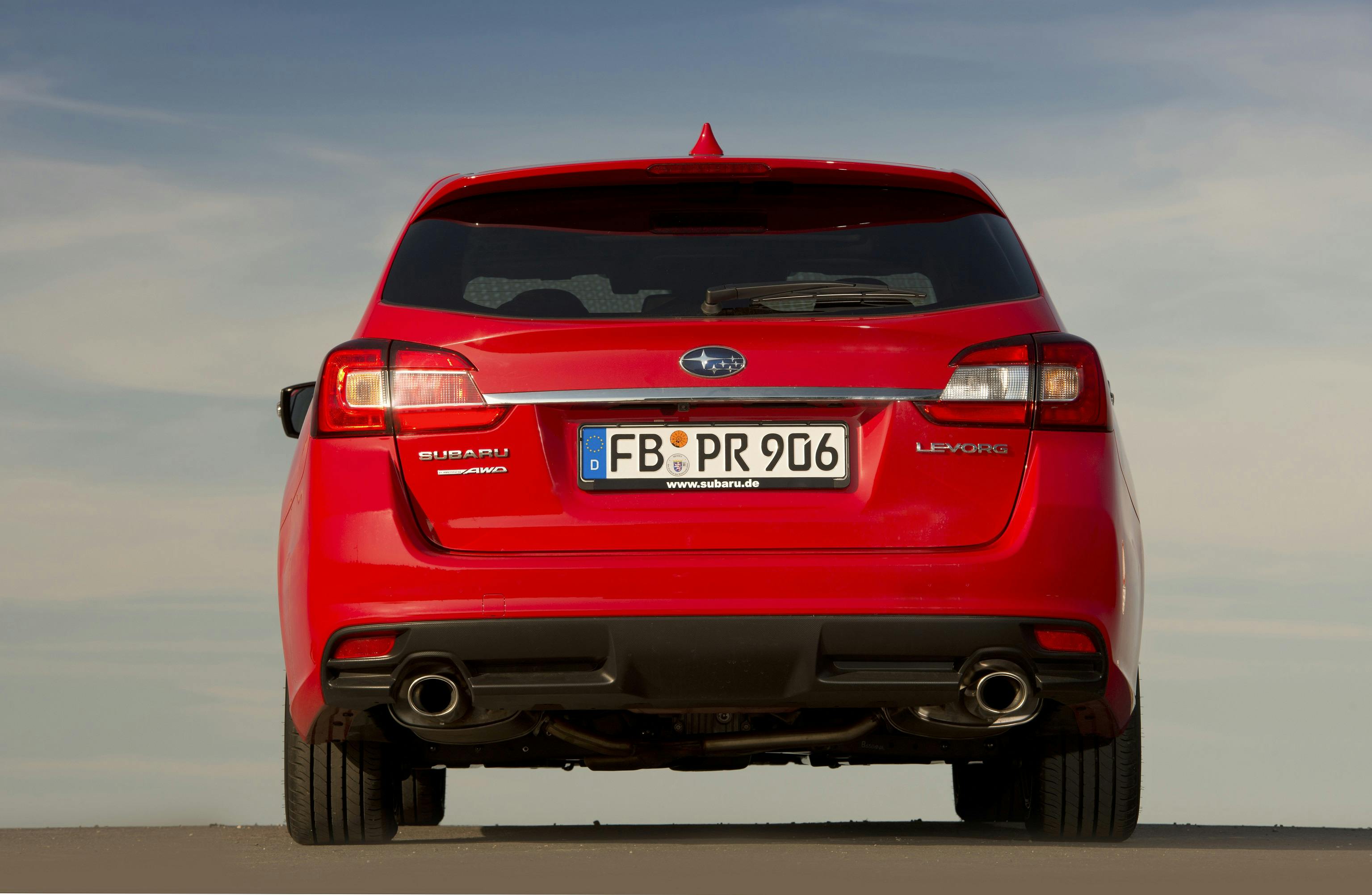 Rotes Auto von hinten mit doppelauspuff. Kennzeichen "FB-PR 906". Blauer Himmel im Hintergrund.