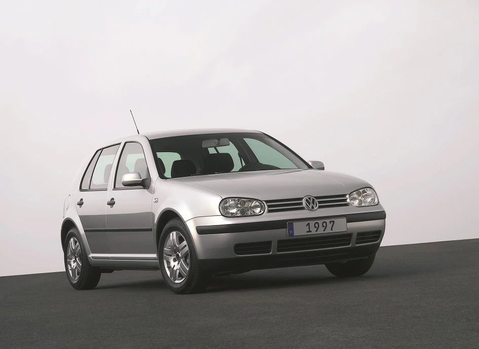 Silberner Volkswagen Golf aus dem Jahr 1997, seitlich auf grauem Boden vor hellem Hintergrund fotografiert.