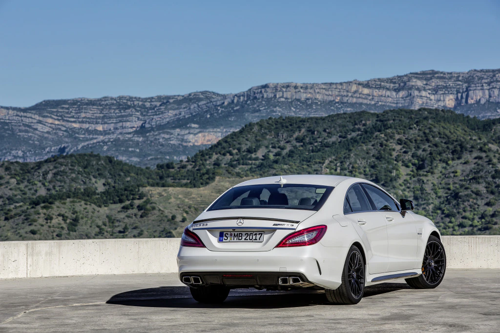Weißer Mercedes-Benz auf einem Parkplatz mit Berglandschaft im Hintergrund.