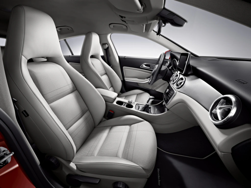 Innenraum eines modernen Autos mit hellgrauen Ledersitzen, elegantem Armaturenbrett und integriertem Display.