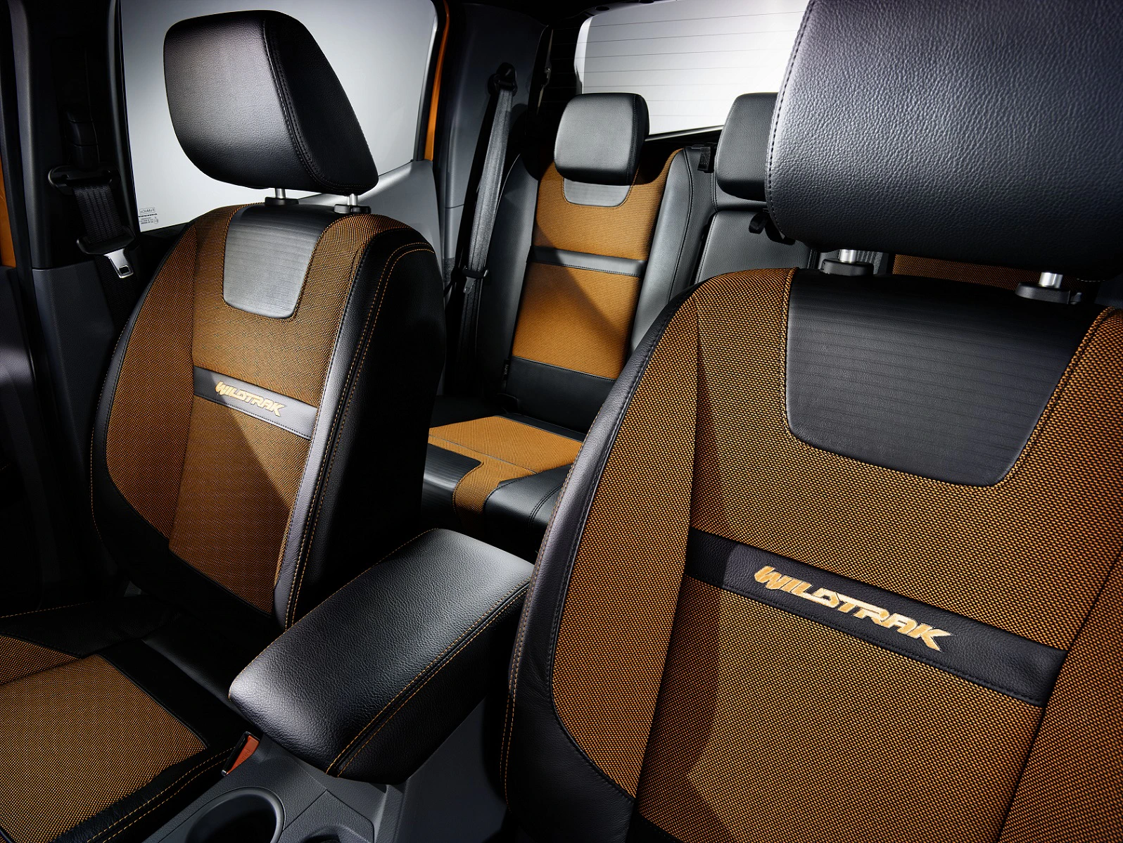 Nahaufnahme von braunen und schwarzen Autositzen mit "Wildtrak"-Logo, modernem Design und Kontrastnähten, Teil eines stilvollen Fahrzeuginnenraums.