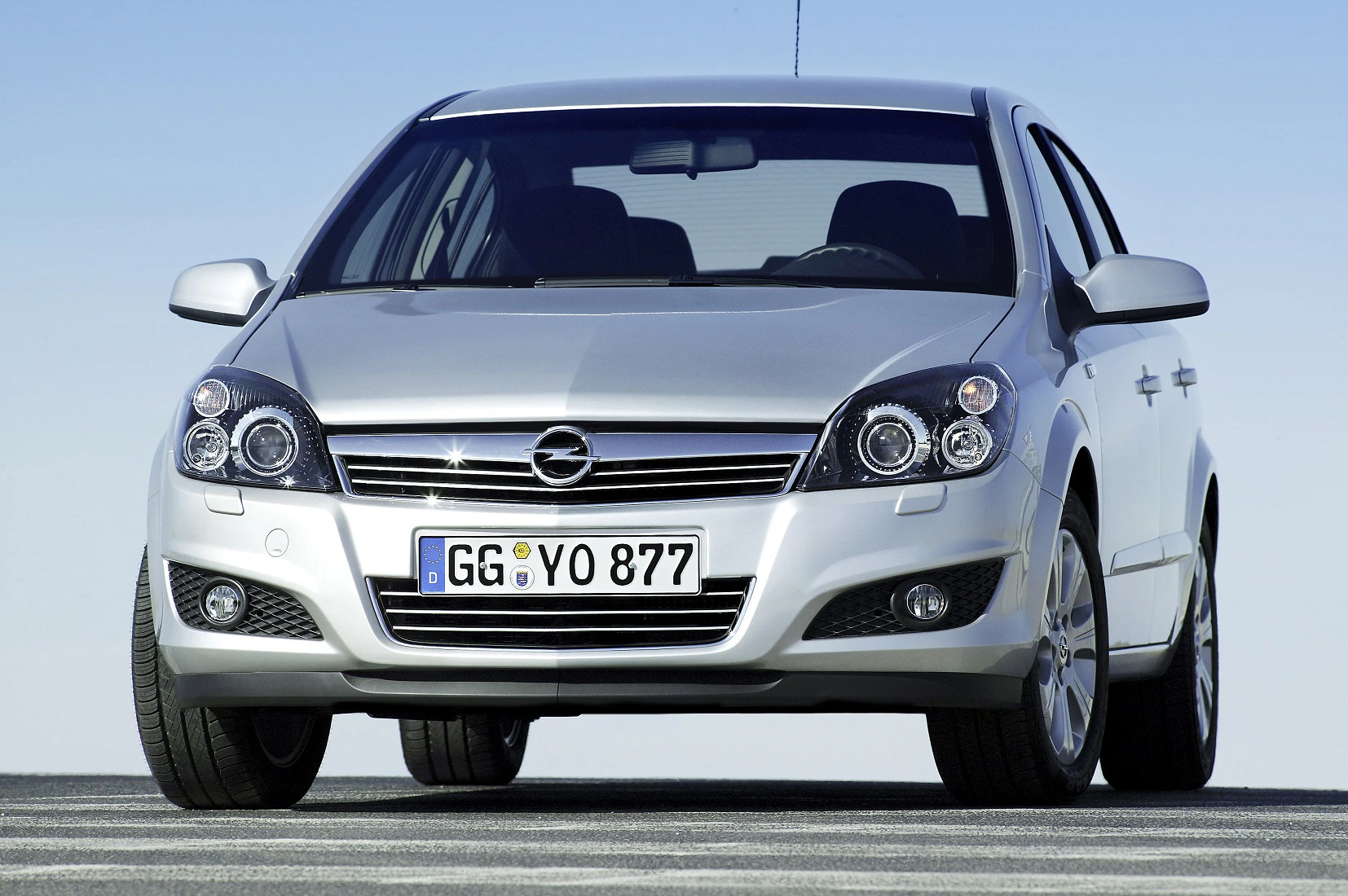 Silberner Opel Astra, Frontansicht auf einer Straße, mit deutschem Kennzeichen. Klarer blauer Himmel im Hintergrund.