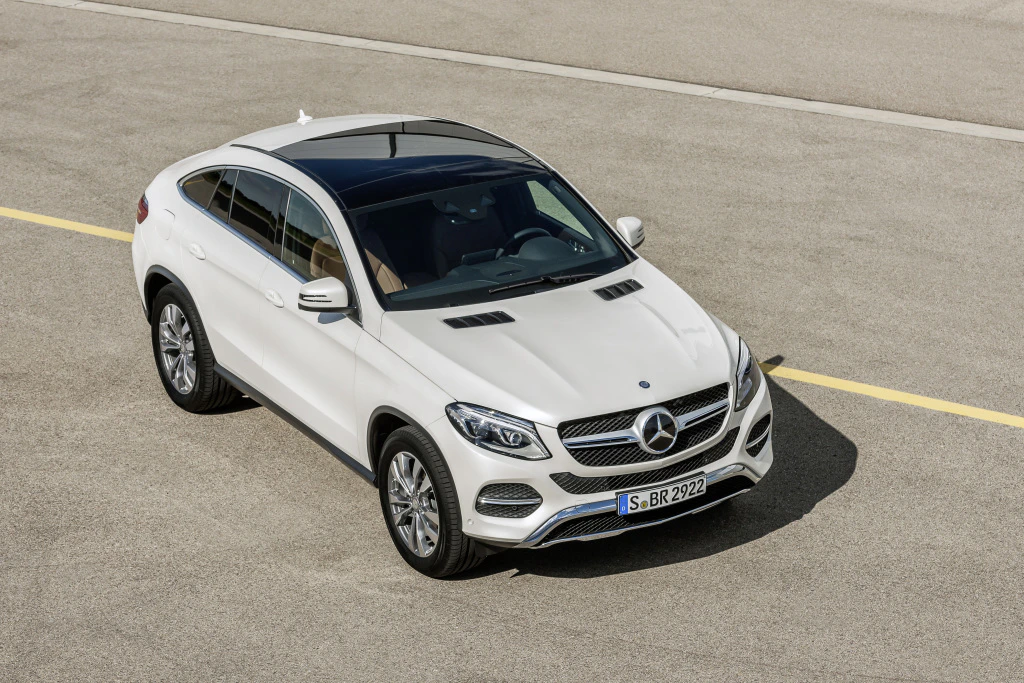 Weißer Mercedes-Benz SUV mit sportlichem Design, fotografiert auf einer freien Straße bei Tageslicht.