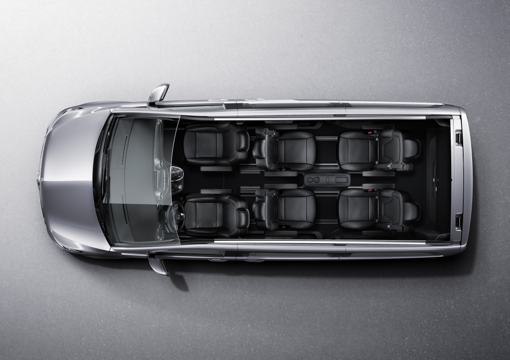 Draufsicht auf einen silbernen Van mit vollständig sichtbarem Innenraum, der drei Sitzreihen zeigt, alle mit schwarzen Polstern.