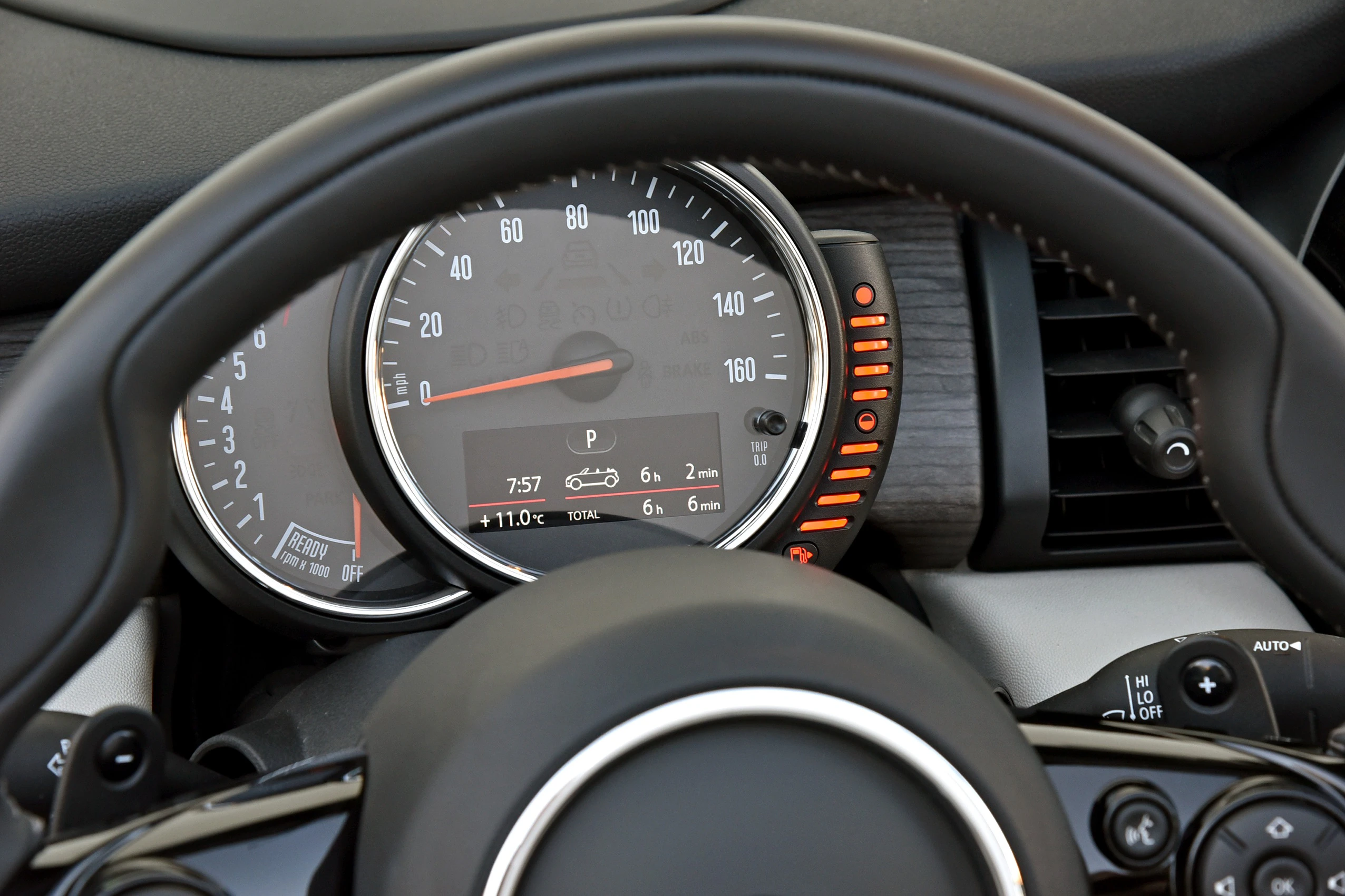 Lenkrad und Tacho eines Autos mit digitaler Anzeige. Geschwindigkeitsskala bis 260 km/h, Parkmodus, Außentemperatur 11°C.
