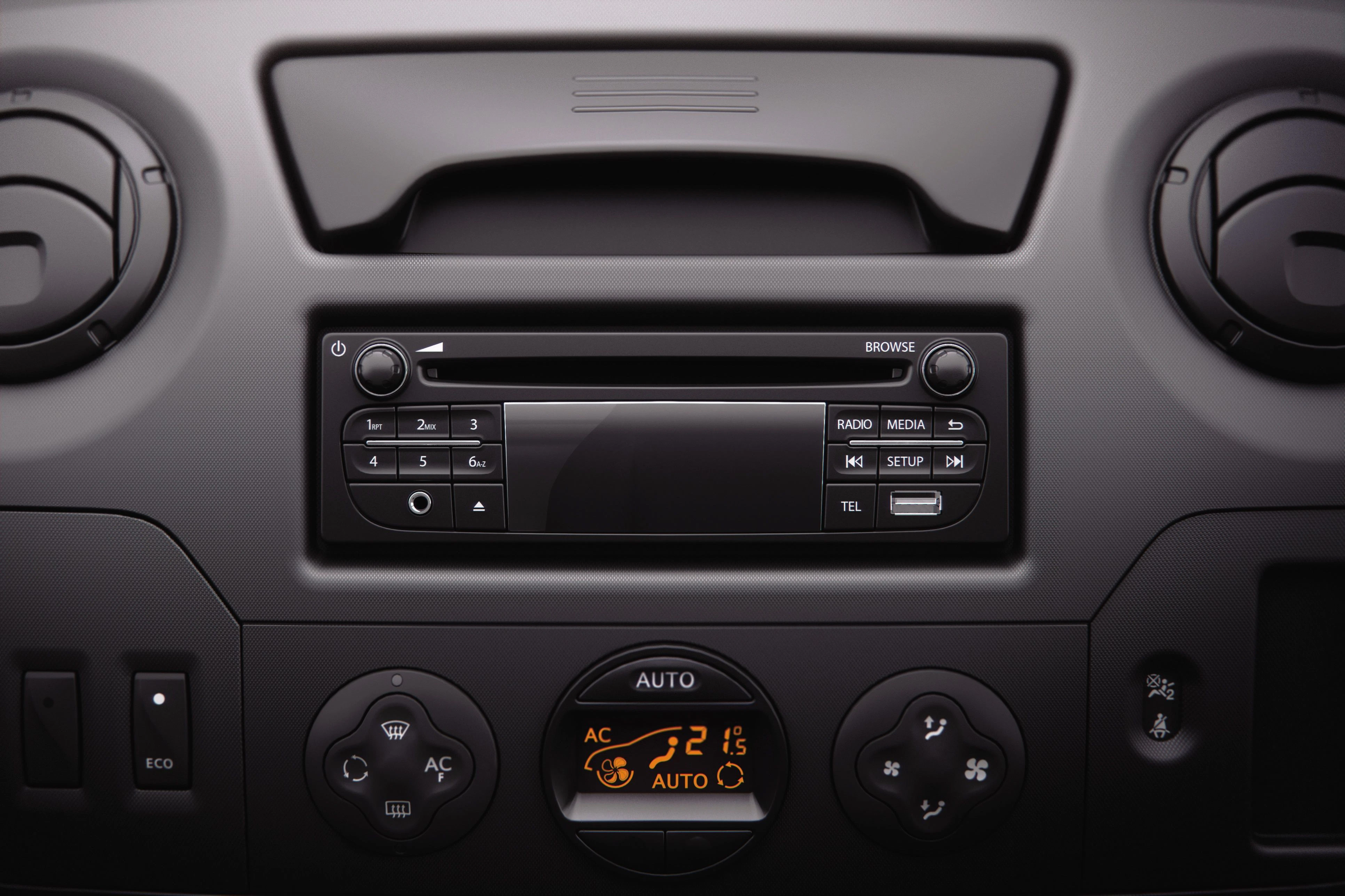 Bedienfeld eines Fahrzeuginnenraums mit Radio, Klimasteuerung und Lüftungsschlitzen, schwarzes Design.