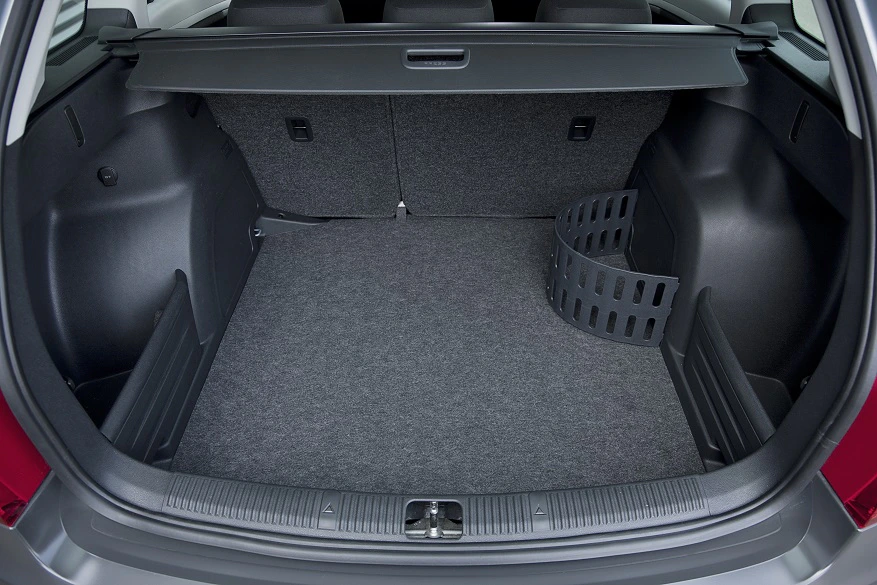 Kofferraum eines Autos mit grauem Teppichboden, eine schwarze, abnehmbare Trennwand auf der rechten Seite.