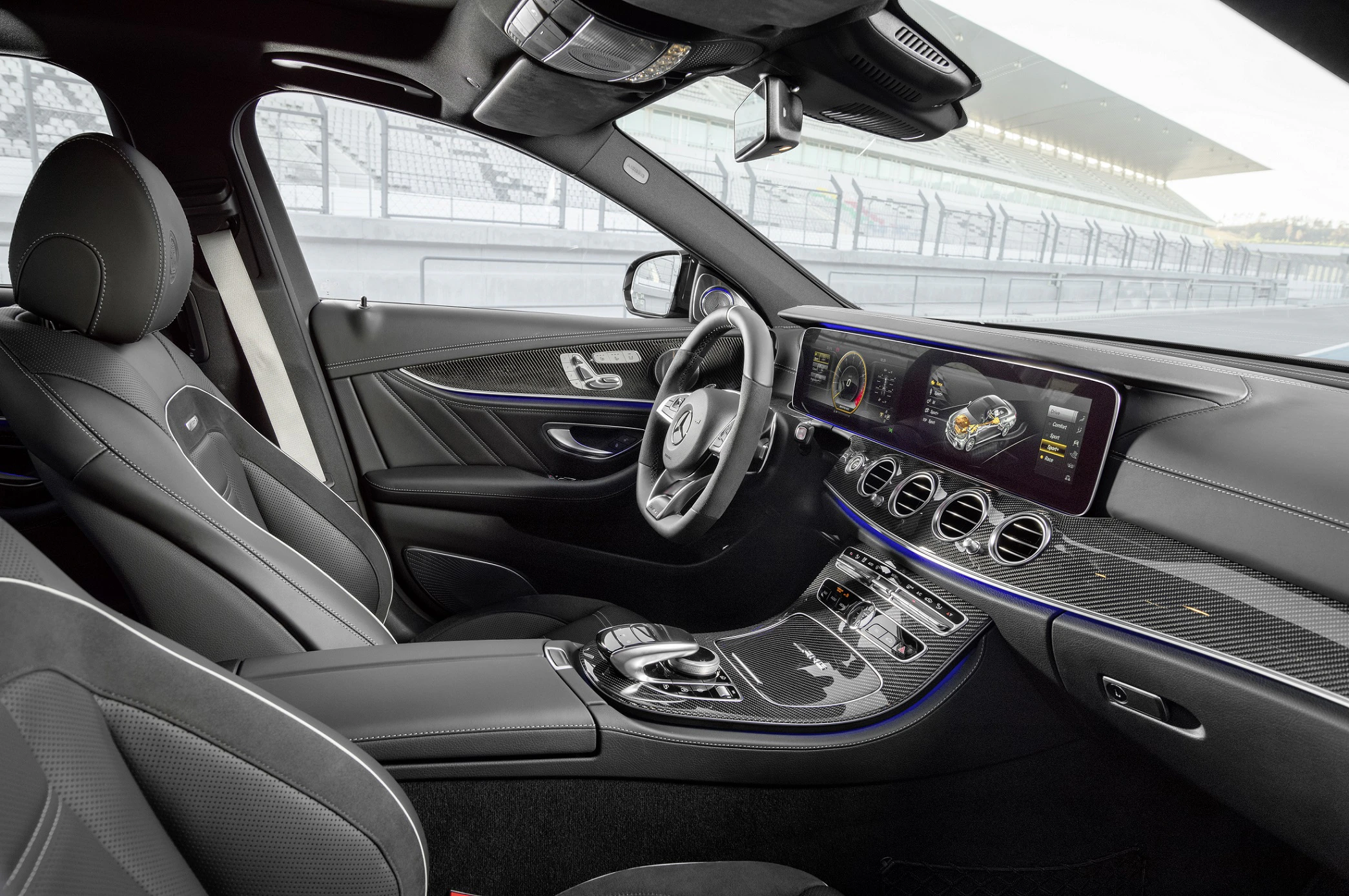 Innenraum eines modernen Autos mit Ledersitzen, digitalem Armaturenbrett und Panoramadach. Blick auf die Fahrbahn durch die Seitenscheiben.
