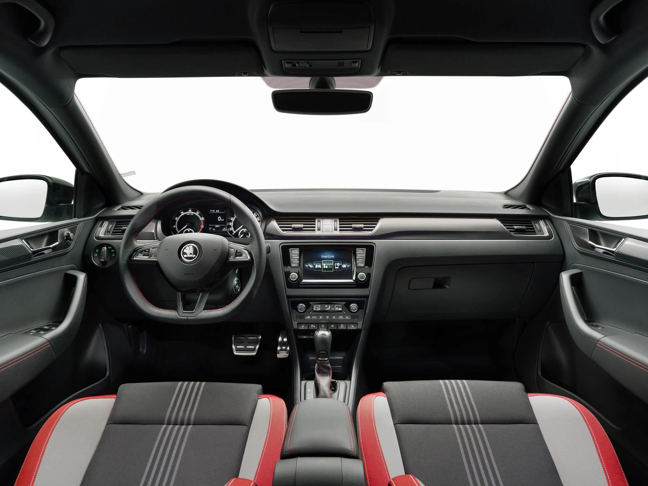 Innenraum eines Autos mit modernem Armaturenbrett, Lenkrad und eingebautem Bildschirm. Sitze in Rot-Schwarz mit weißen Streifen.