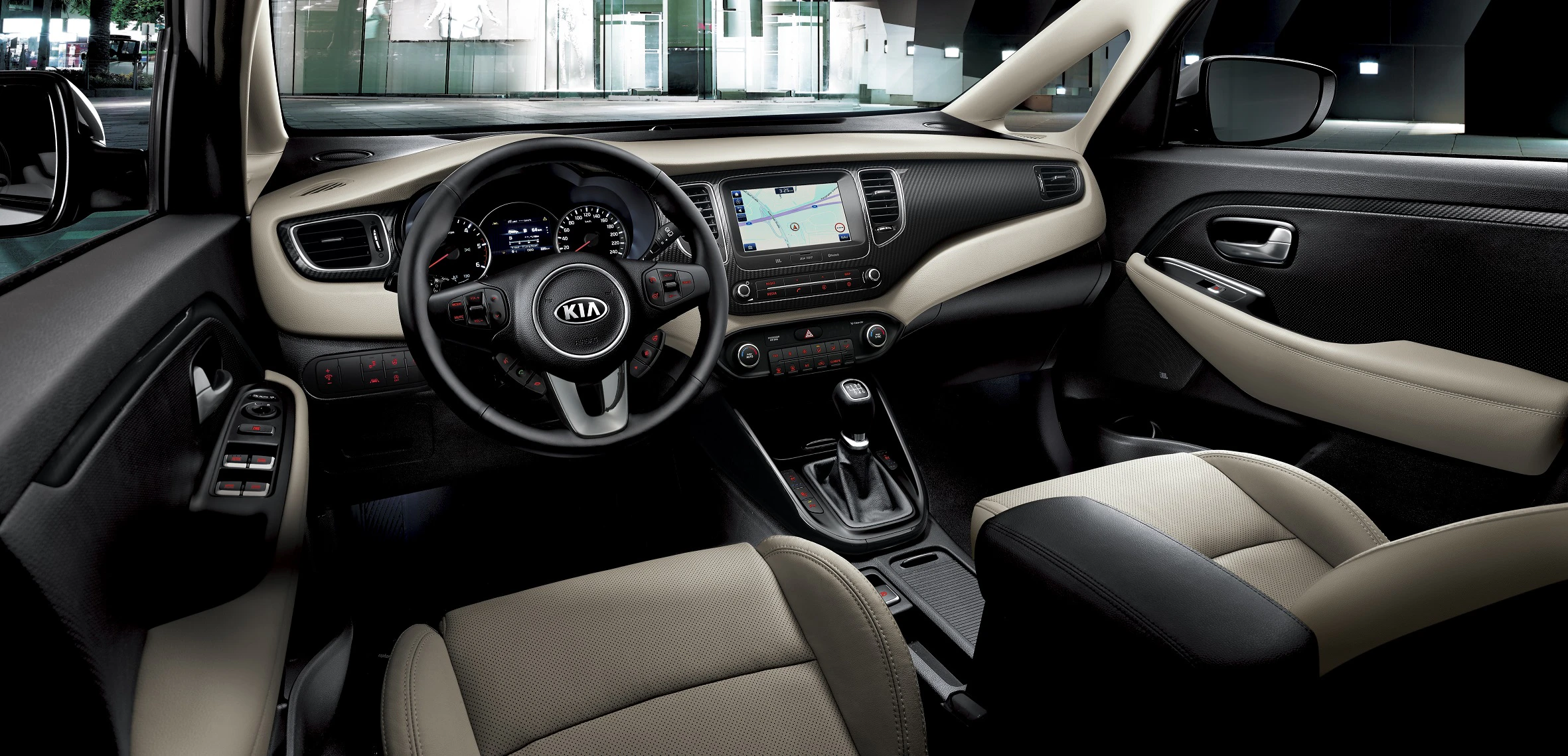 Innenraum eines Autos mit modernem Lenkrad, Touchscreen-Display und beigen Ledersitzen. Helle Beleuchtung im Hintergrund.