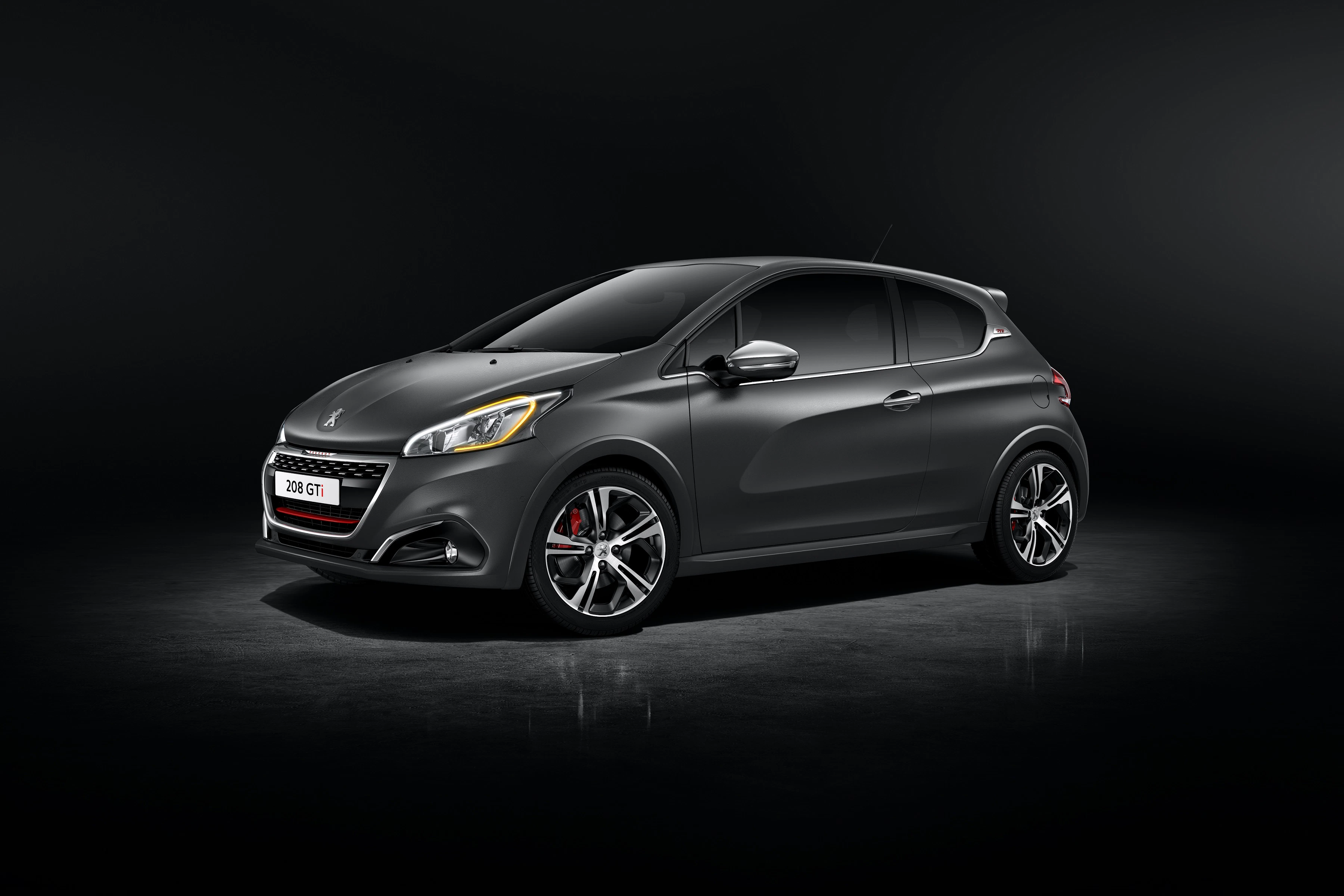 Graues Auto mit sportlichem Design, modernen Scheinwerfern und großen Felgen, auf dunklem Hintergrund.