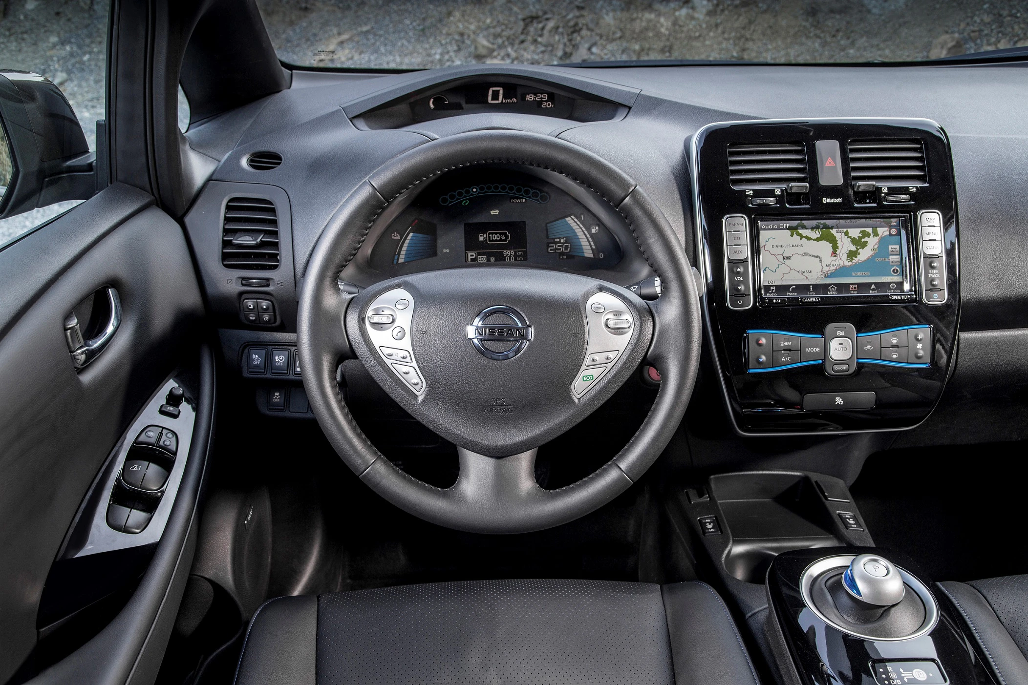 Innenraum eines Autos mit modernem Armaturenbrett. Lenkrad mit Multifunktionstasten, zentralem Display, Navigationssystem und Schalthebel.