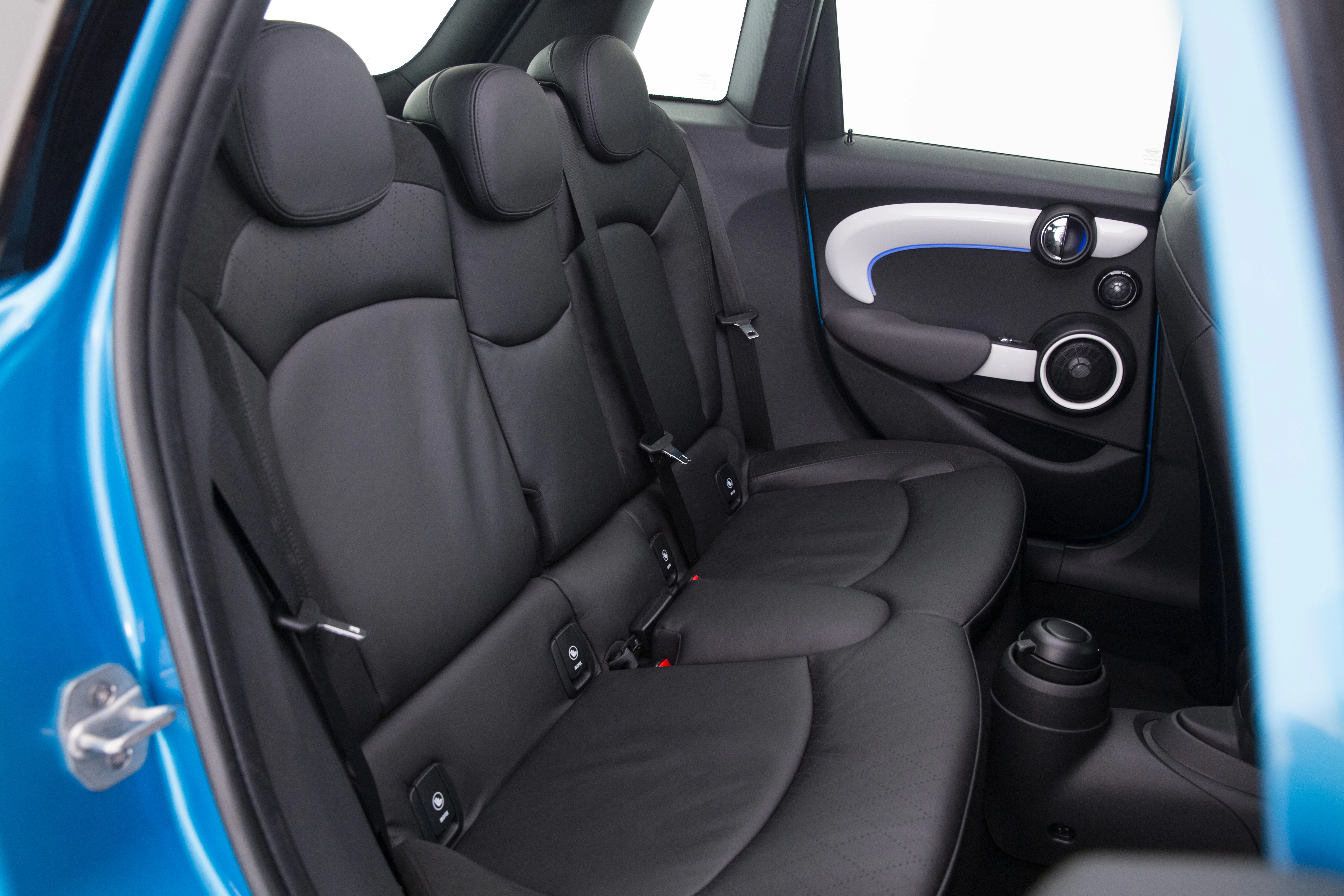 Rückansicht eines Autos mit schwarzer Lederausstattung; drei Sitze, blaue Türverkleidung und Getränkehalter an der Seite.