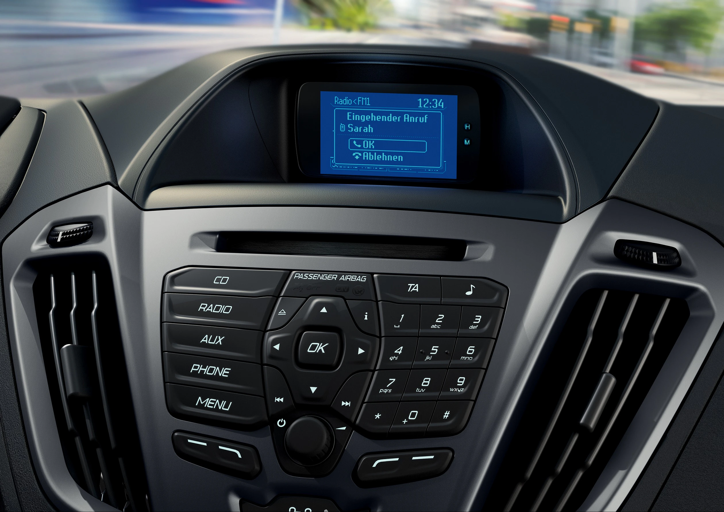 Nahaufnahme eines Autoinnenraums mit einem Autoradio-Display und Bedientasten. Auf dem Display wird ein eingehender Anruf angezeigt.