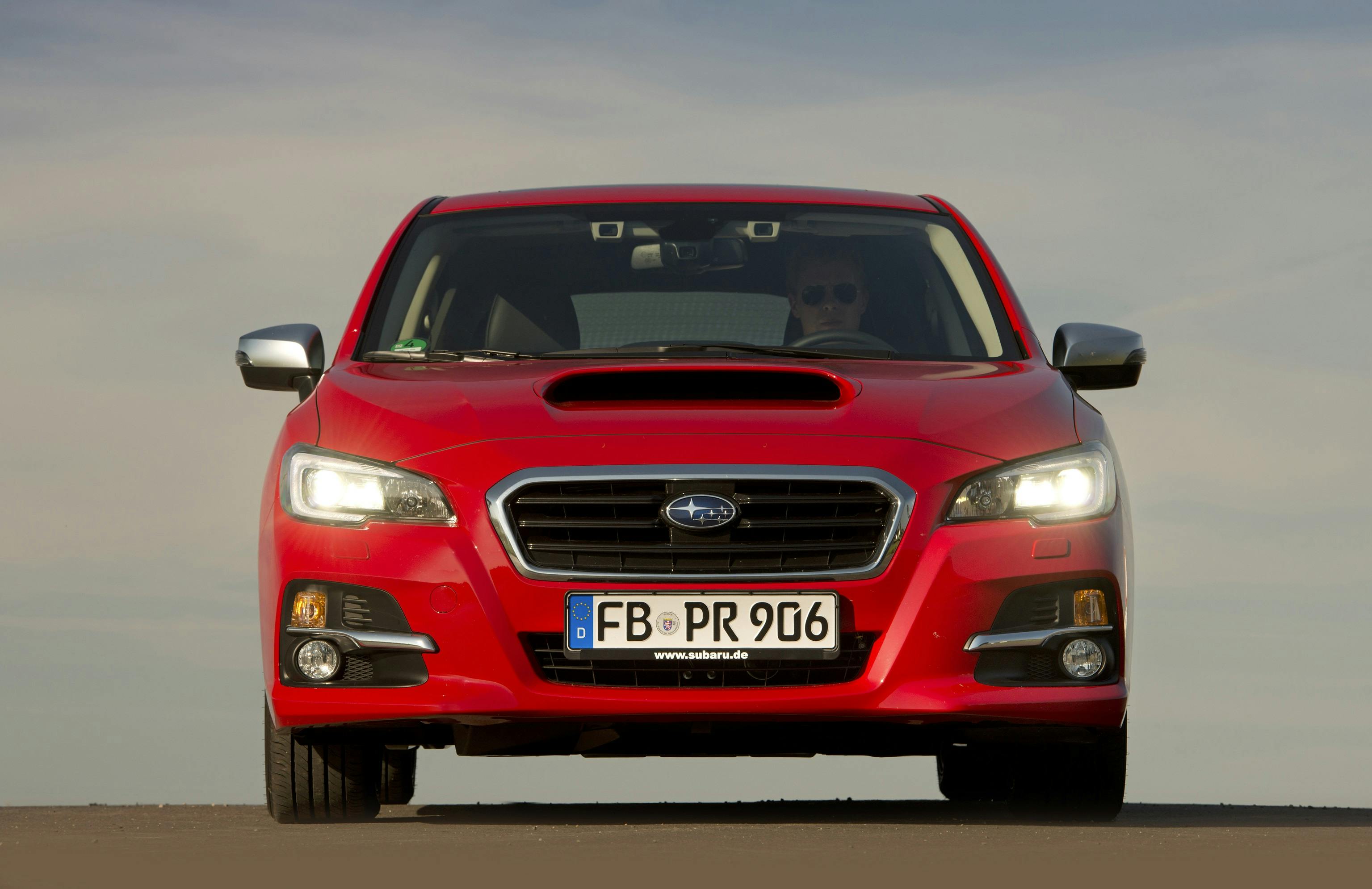Rotes Auto der Marke Subaru mit deutschem Kennzeichen, frontal auf einer Straße stehend, bei Tageslicht fotografiert.