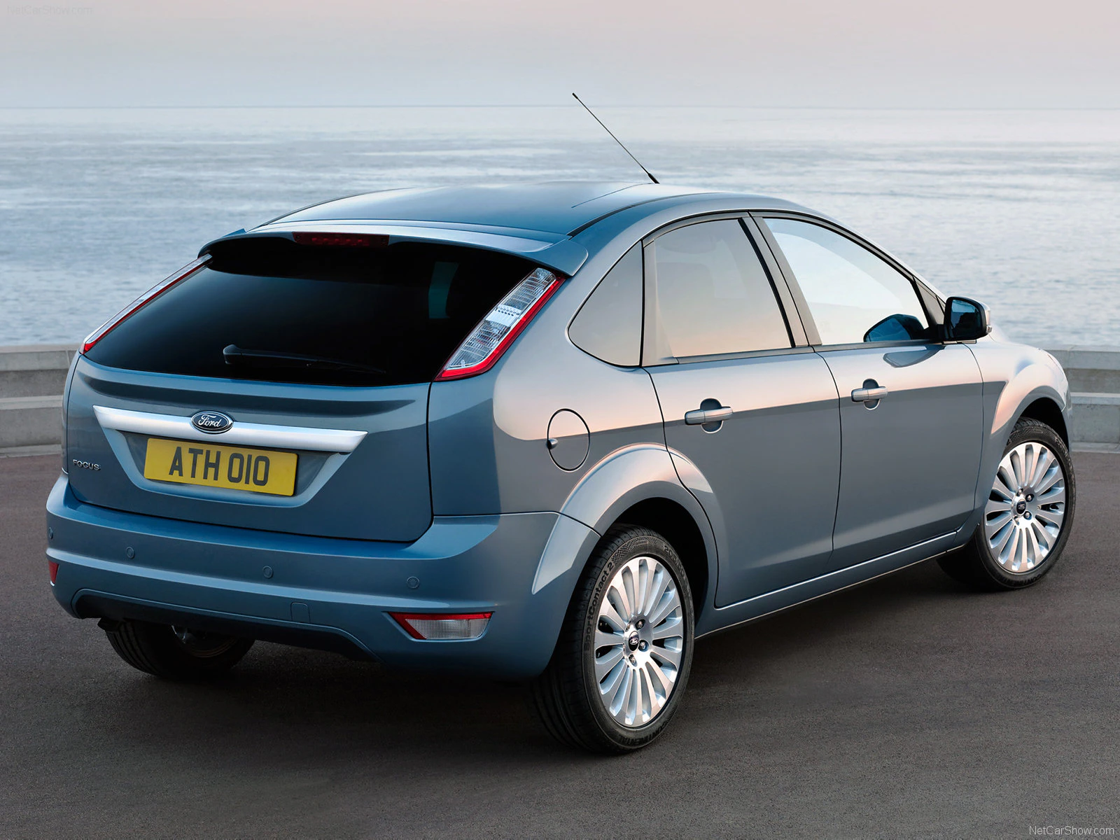 Blauer Ford Focus steht auf einer Küstenstraße mit Meeresblick im Hintergrund. Fahrzeug zeigt das Heck mit sichtbarem Nummernschild.