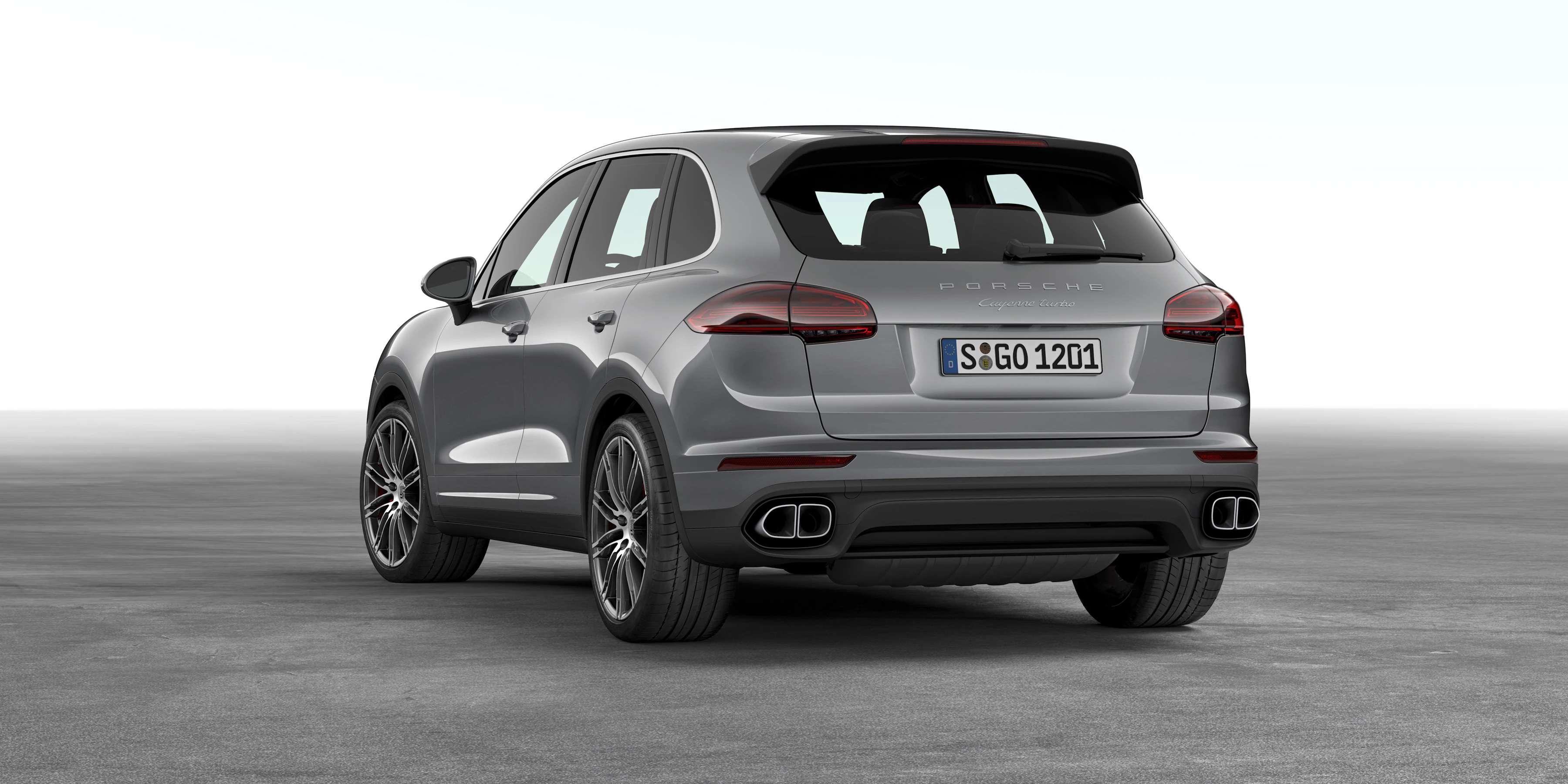 Rückansicht eines grauen SUV mit sportlichem Design und Doppelrohrauspuff, stehend auf grauem Hintergrund.