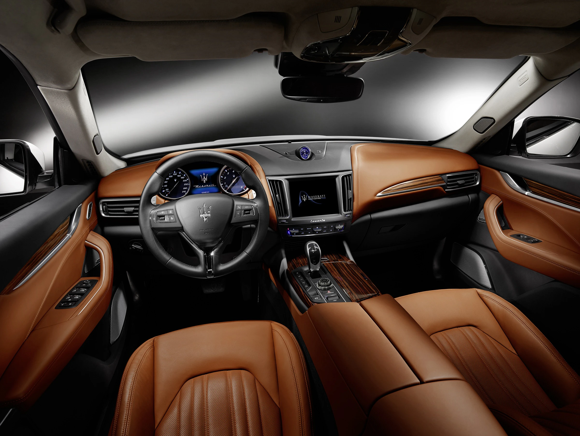 Innenraum eines Luxusautos mit braunen Ledersitzen, modernem Armaturenbrett und Lenkrad. Elegantes Design und hochwertige Materialien.