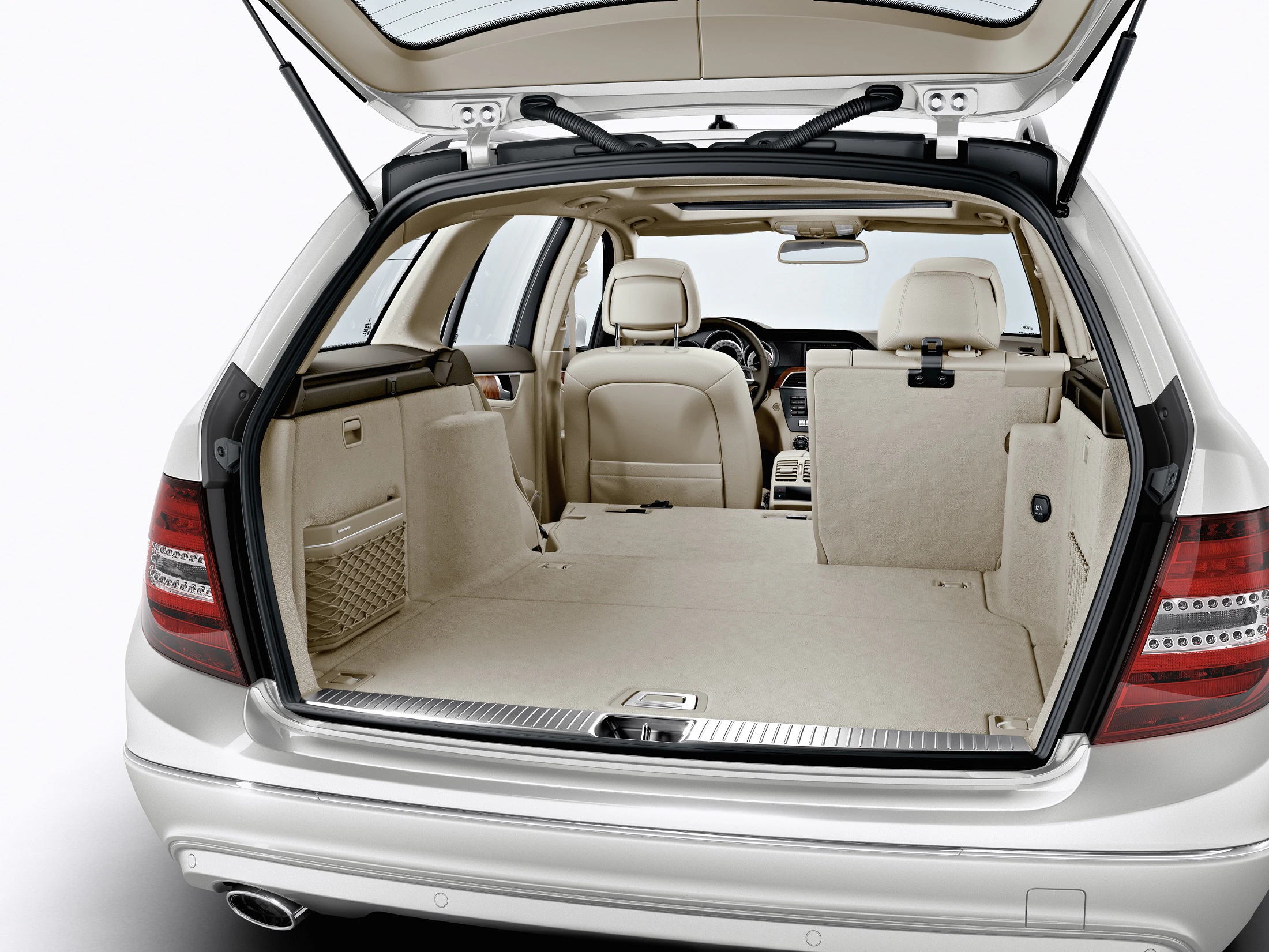 Offener Kofferraum eines silbernen Autos mit beige Innenausstattung, Blick von hinten nach vorne auf die Rücksitze und Armaturenbrett.