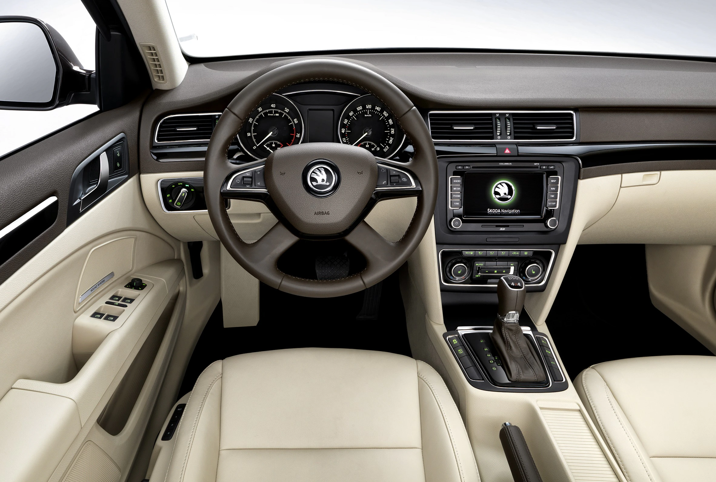 Innenraum eines Autos mit beigem Leder, Lenkrad mit Skoda-Logo, modernem Armaturenbrett und Infotainment-Bildschirm.