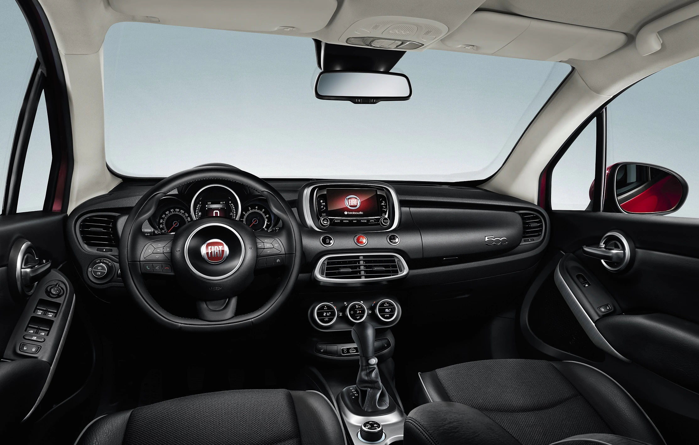 Innenraum eines Autos mit schwarzer Polsterung, einem Multifunktionslenkrad, zentralem Touchscreen und modernen Armaturen.