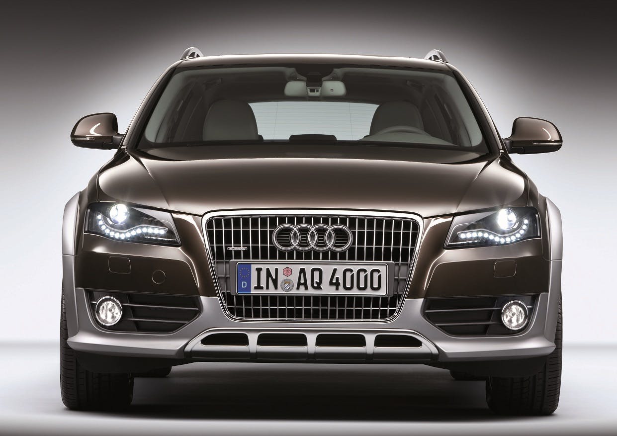 Frontansicht eines braunen Audi Q5 mit LED-Scheinwerfern und deutschem Kennzeichen auf grauem Hintergrund.