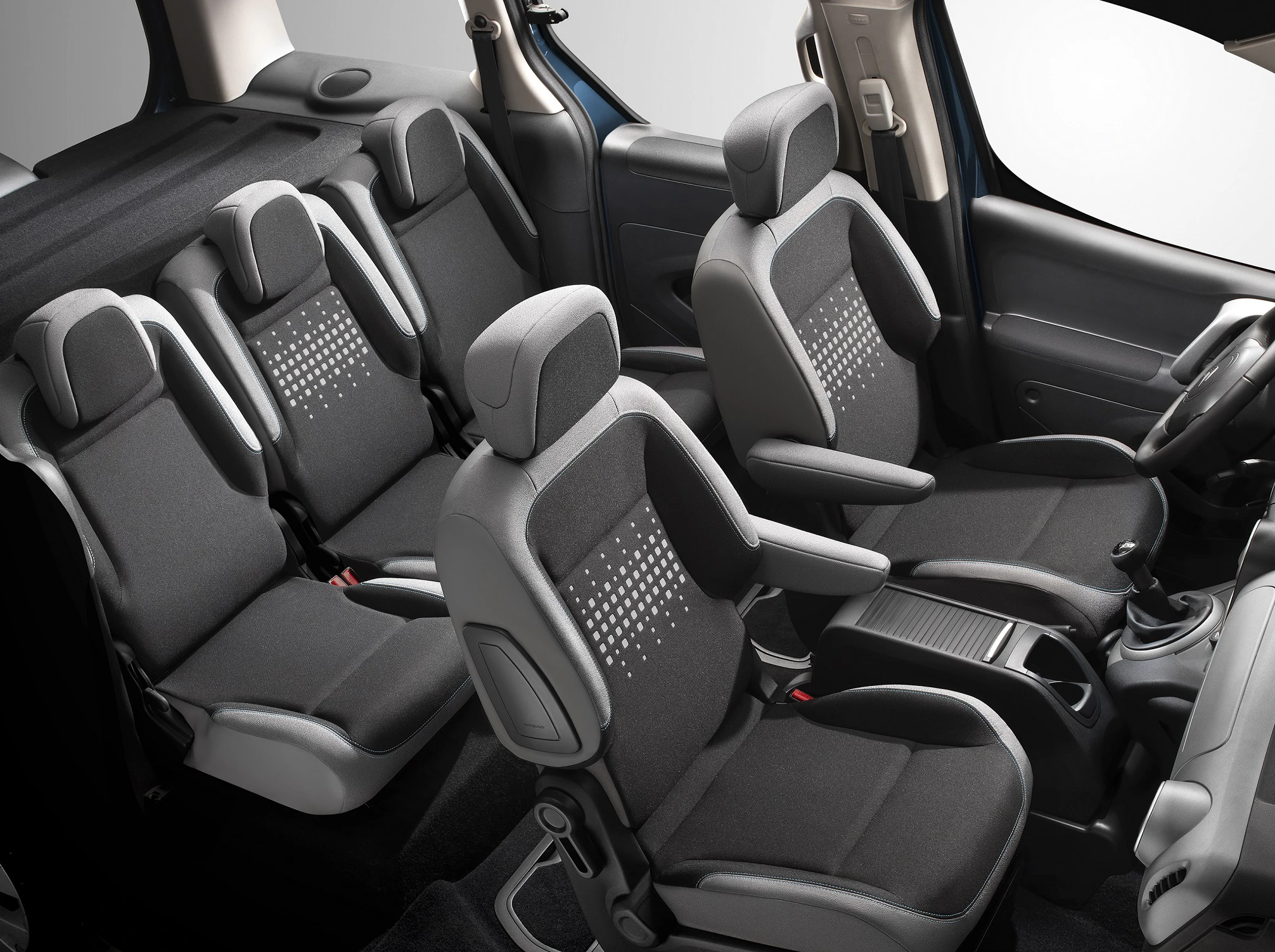 Innenraum eines Autos mit drei Sitzreihen, bestehend aus sieben schwarzen Einzelsitzen, die bequem und modern gestaltet sind.