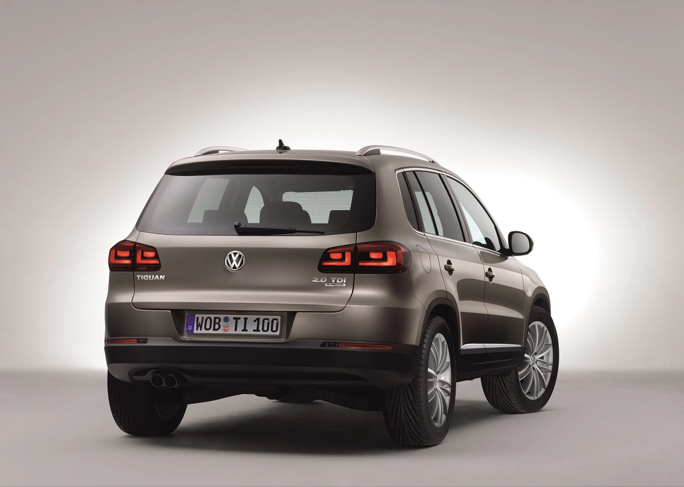Silberner Volkswagen Tiguan, Rückansicht. Im Studio mit hellem Hintergrund fotografiert. Kennzeichen: WOB TI 100.
