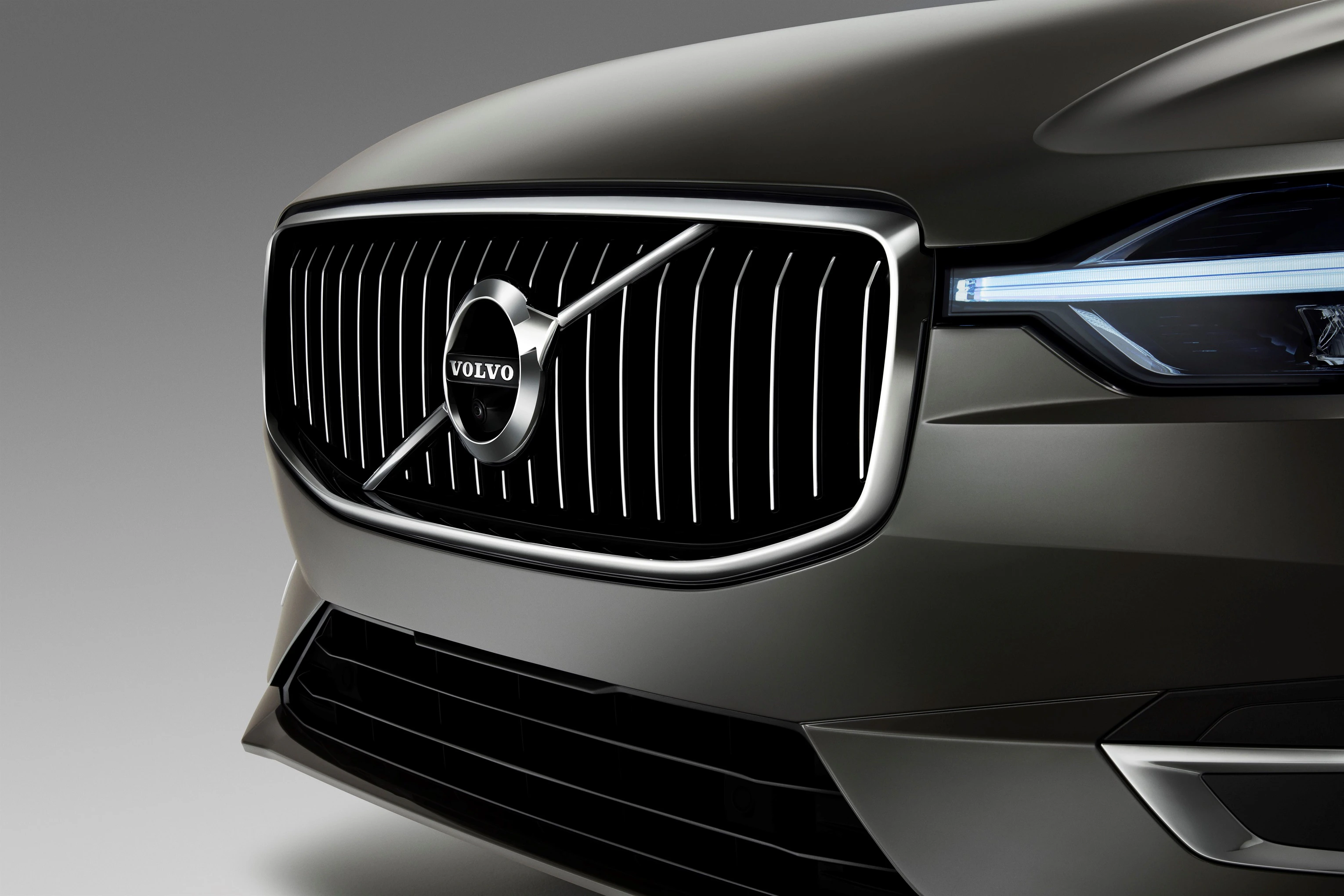 Vorderansicht eines Volvo-Kühlergrills in Nahaufnahme, mit markantem Logo und modernen Scheinwerfern.