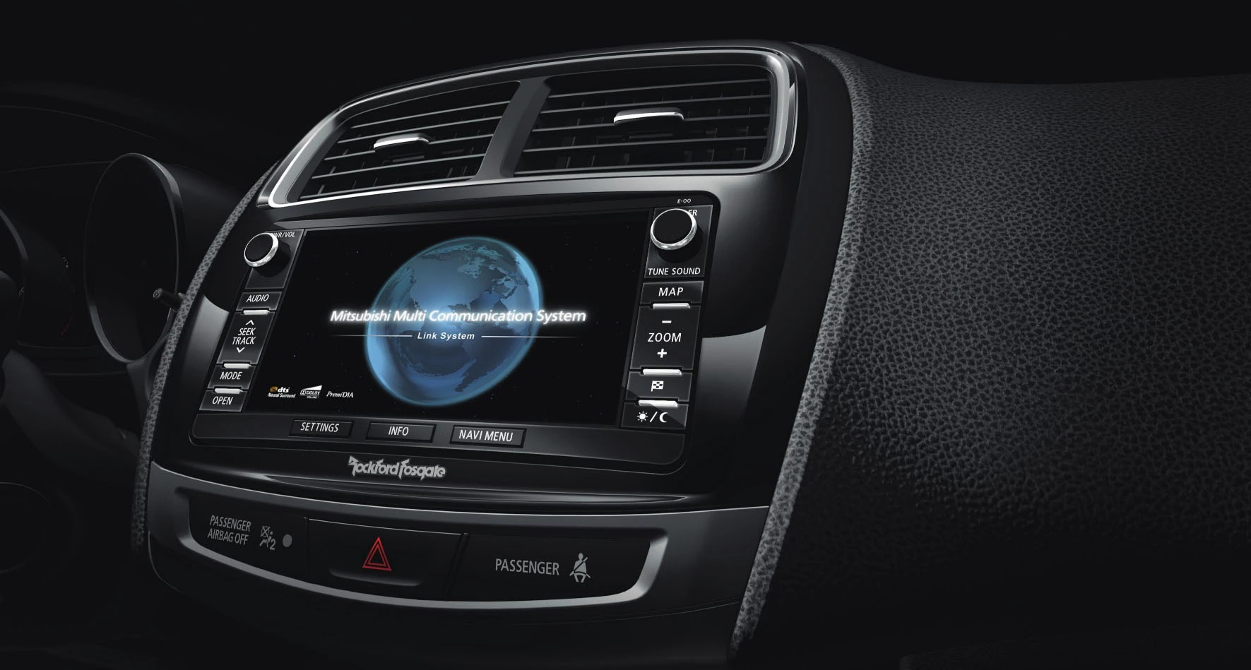 Nahaufnahme eines Auto-Armaturenbretts mit einem Bildschirm, der das Mitsubishi Multi Communication System zeigt.