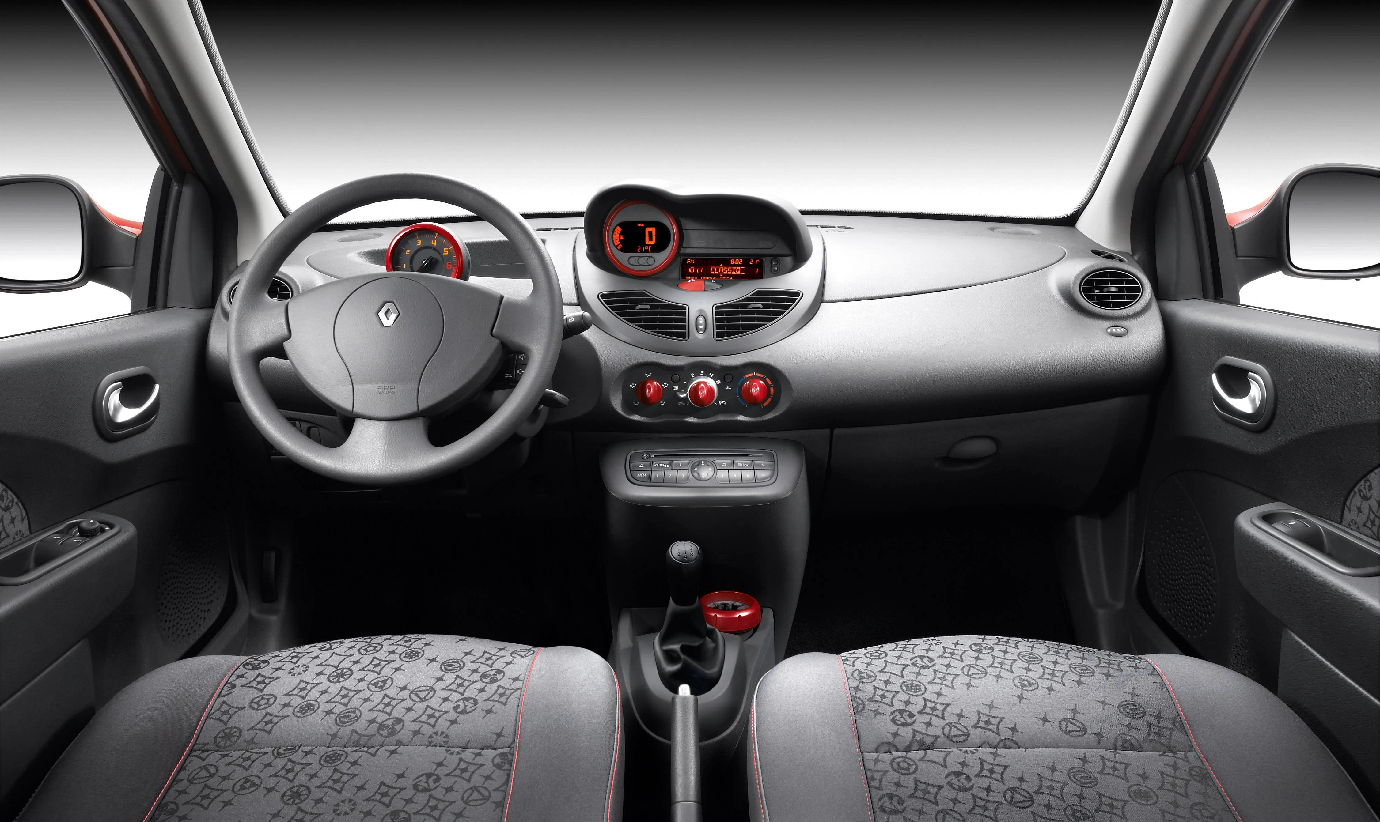 Innenansicht eines modernen Autos mit schwarzem Armaturenbrett, Lenkrad, digitalen Anzeigen und grauen Sitzen mit Muster.