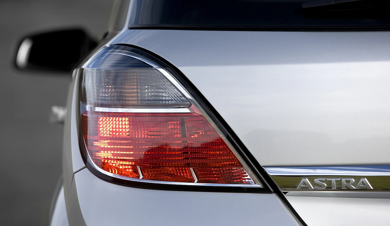 Nahaufnahme eines grauen Autos mit klarem Rücklichtdesign und dem Schriftzug "Astra" auf der Karosserie.