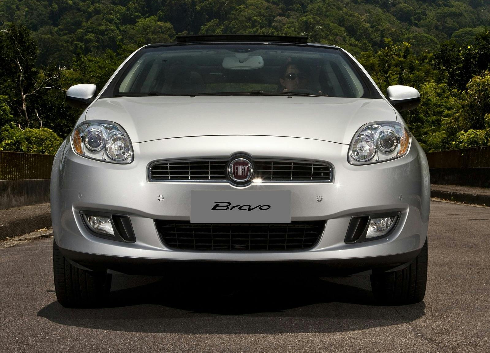 Silberner Fiat Bravo, frontal fotografiert, auf einer Straße mit grünem bewaldeten Hintergrund an einem sonnigen Tag.