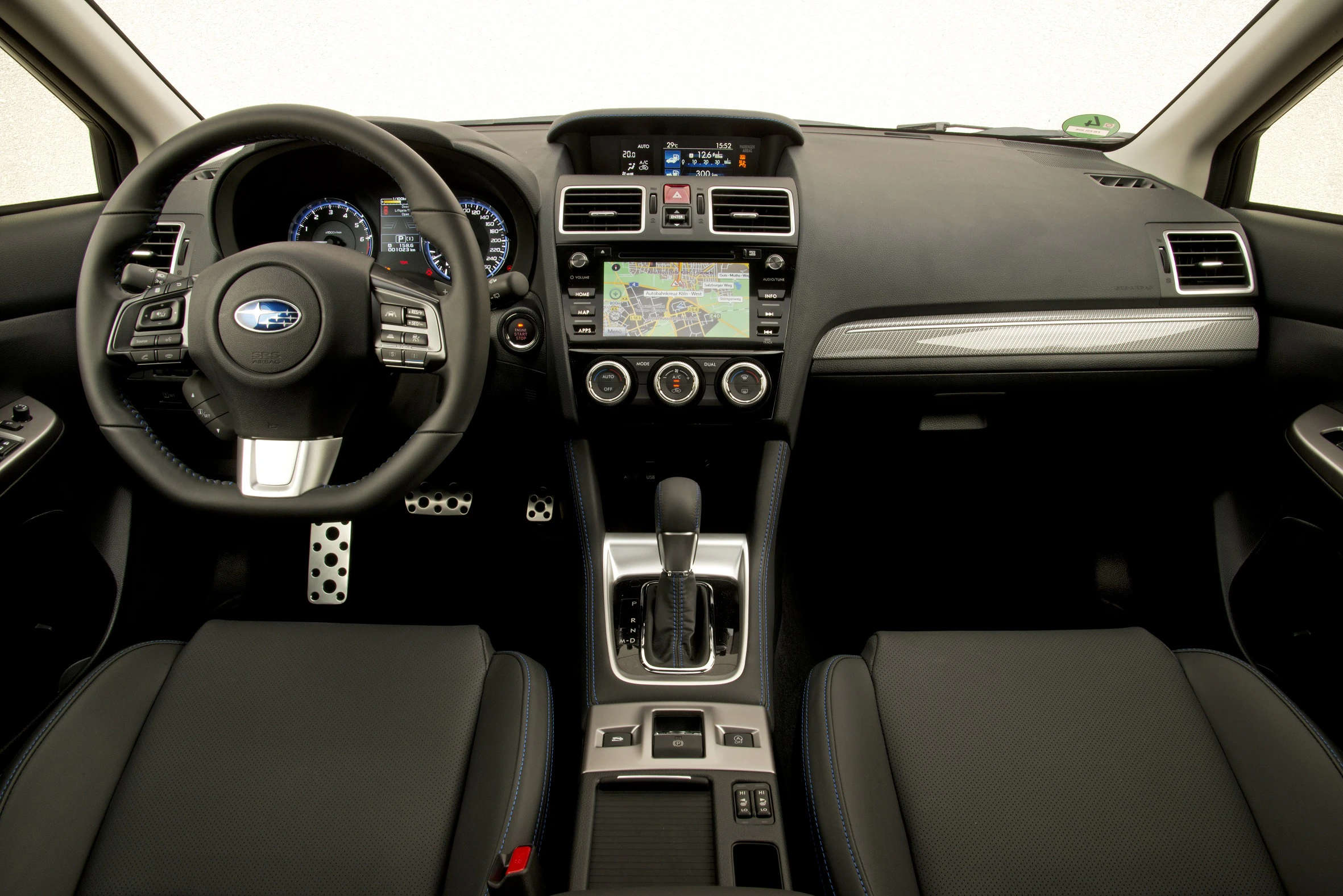 Innenraum eines Autos mit schwarzer Lederausstattung, einem zentralen Touchscreen-Navigationssystem und einem multifunktionalen Lenkrad.