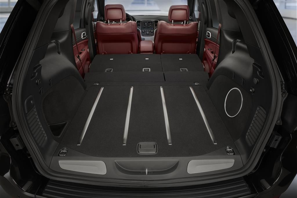 Großer Kofferraum eines SUV mit heruntergeklappten Rücksitzen und roten Vordersitzen. Viel Ladefläche, ideal für Transportzwecke.