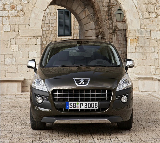 Dunkelgrauer Peugeot 3008 steht vor einem steinernen Torbogen auf gepflastertem Platz, mit historischer Steinmauer im Hintergrund.