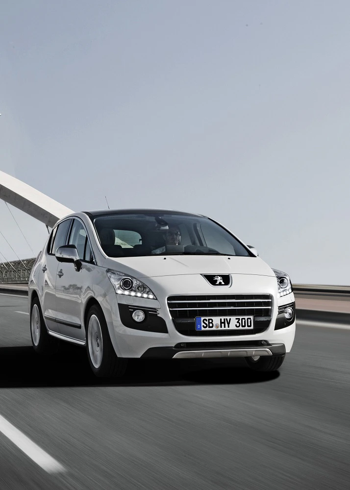 Weißes Auto fährt auf einer Autobahn, mit einer Brücke im Hintergrund. Es ist ein Peugeot mit deutschem Kennzeichen.