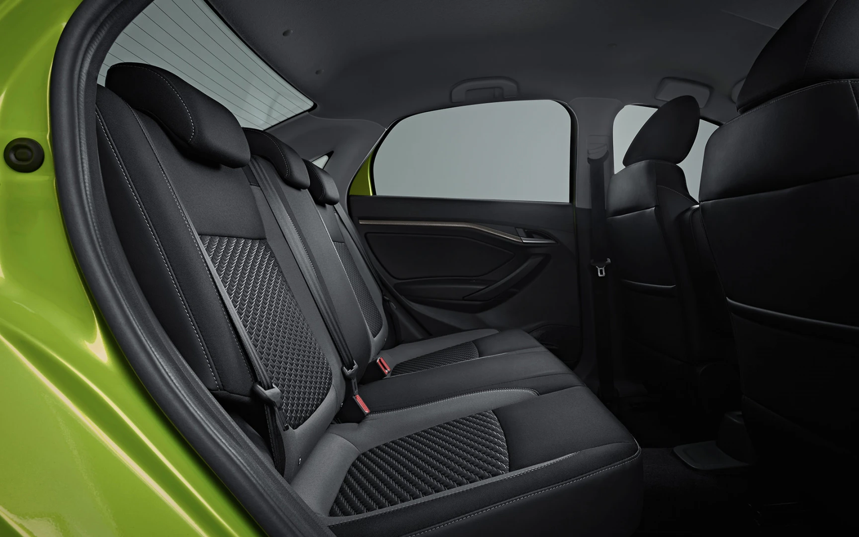 Rückansicht des Innenraums eines grünen Autos mit schwarzen Ledersitzen und roten Sicherheitsgurten.