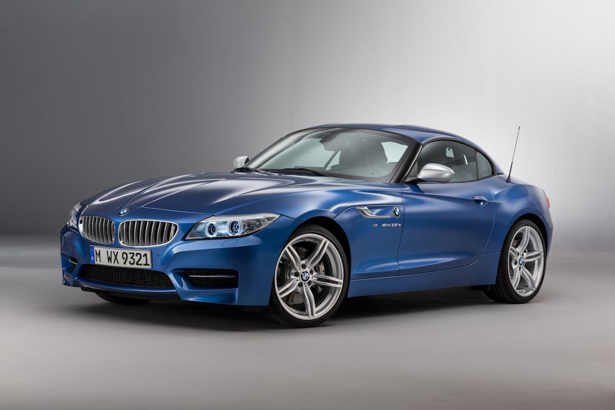 Blauer BMW Z4 Sportwagen, Dreiviertelansicht von vorne. Silberne Felgen, schlankes Design. Hintergrund in Grautönen.
