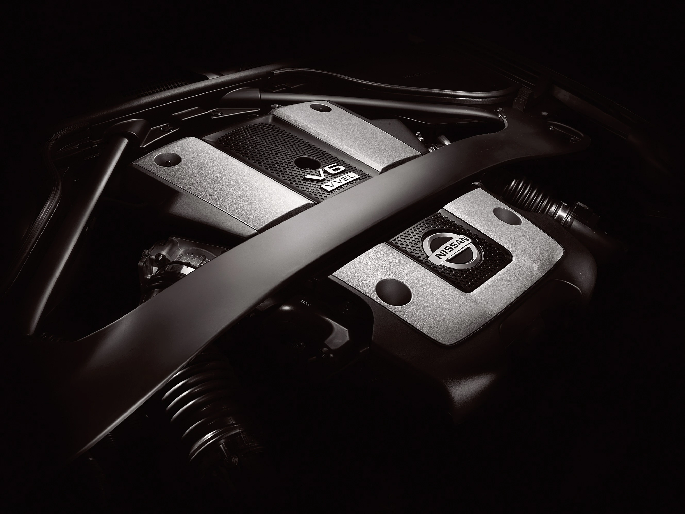 Nahaufnahme eines kraftvollen V6-Motors in einem Auto, mit einem Nissan-Logo auf dunklem Hintergrund.