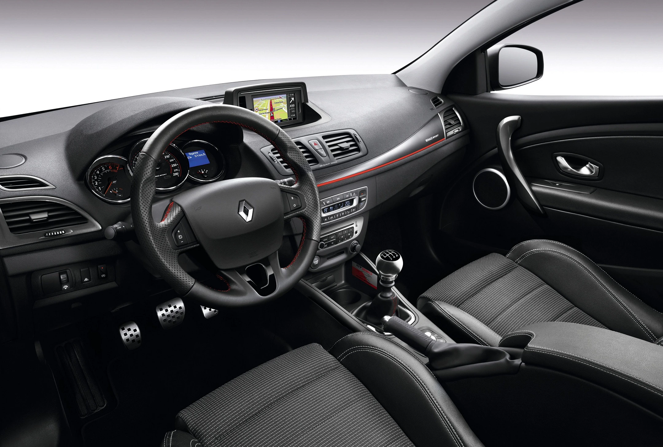 Innenraum eines Autos mit Lenkrad, Schalthebel und Tachometeranzeige. Das Armaturenbrett enthält ein Navigationssystem.