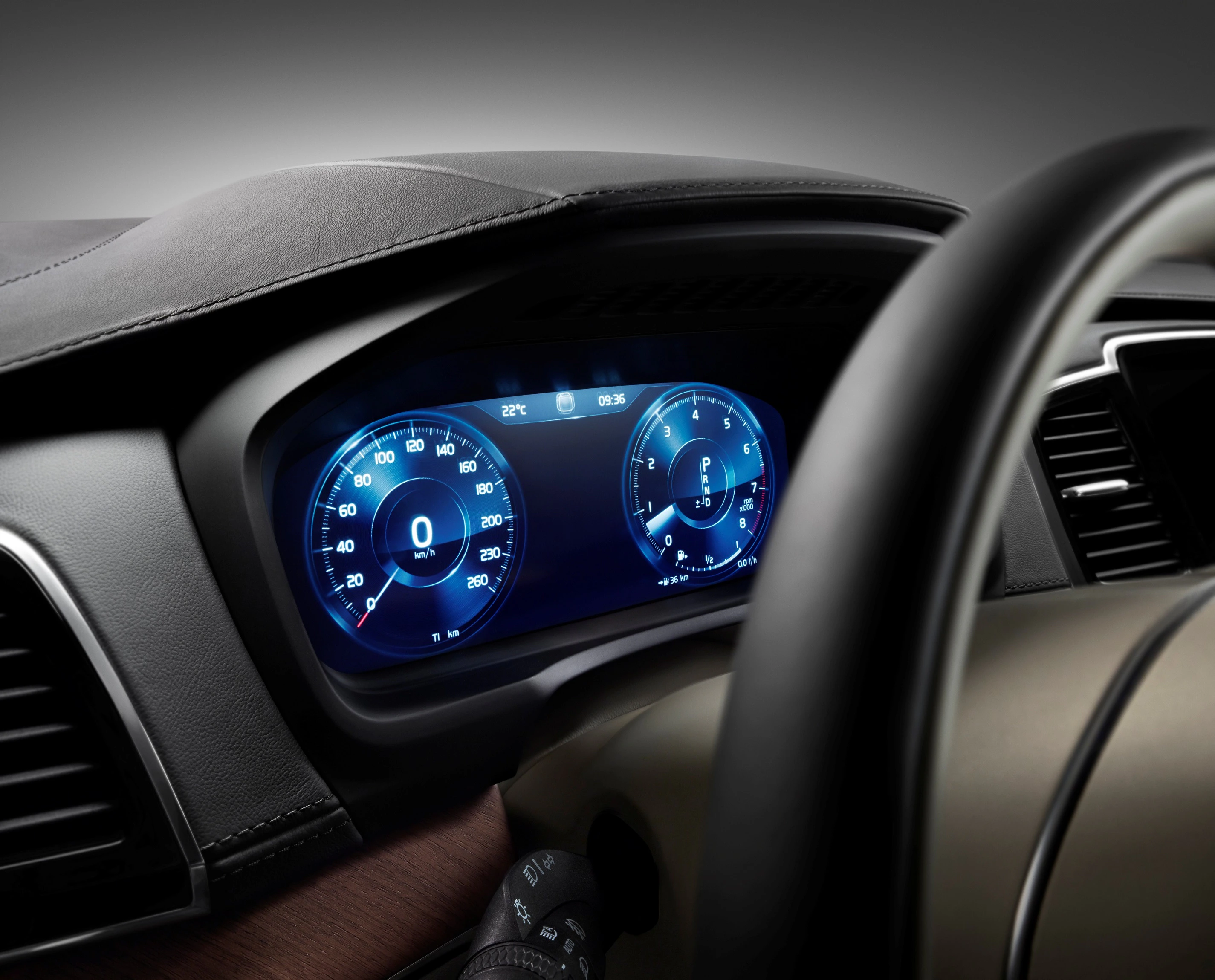Nahaufnahme eines modernen Autoarmaturenbretts mit digitalem Tachometer, blau beleuchtetem Display und Temperaturanzeige.