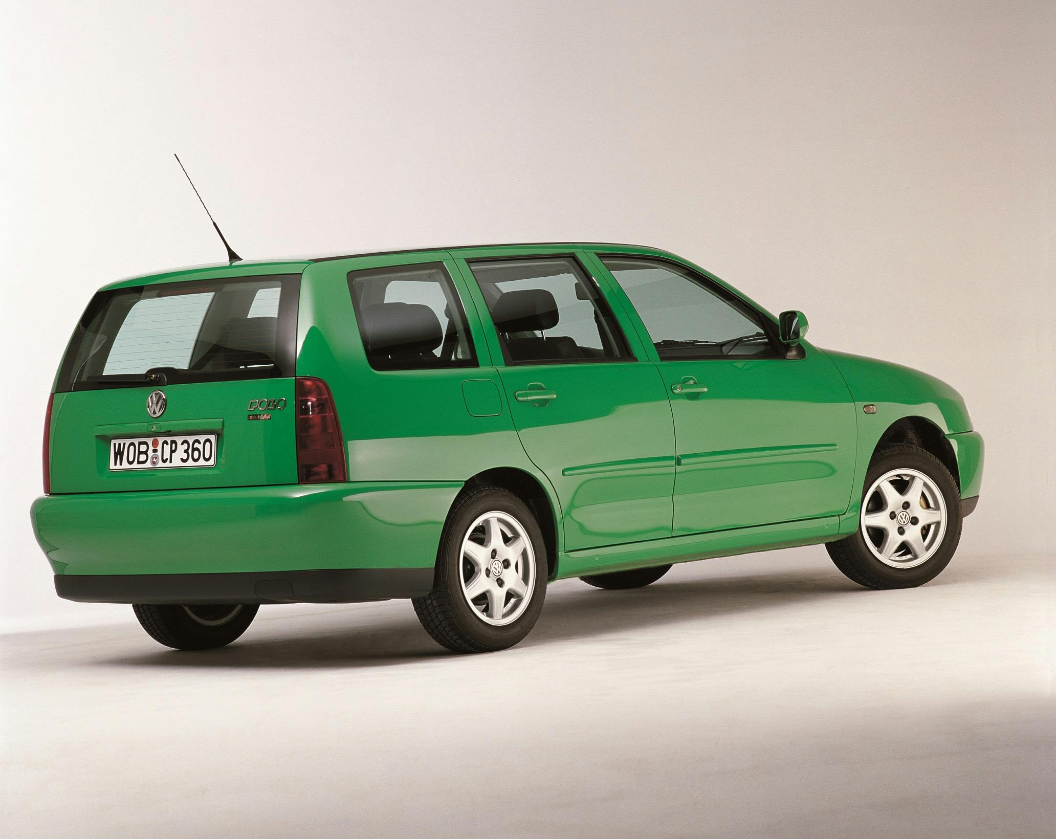 Grüner VW Polo Variant Kombi aus den 1990er Jahren, Seitenansicht von hinten auf hellem Hintergrund.